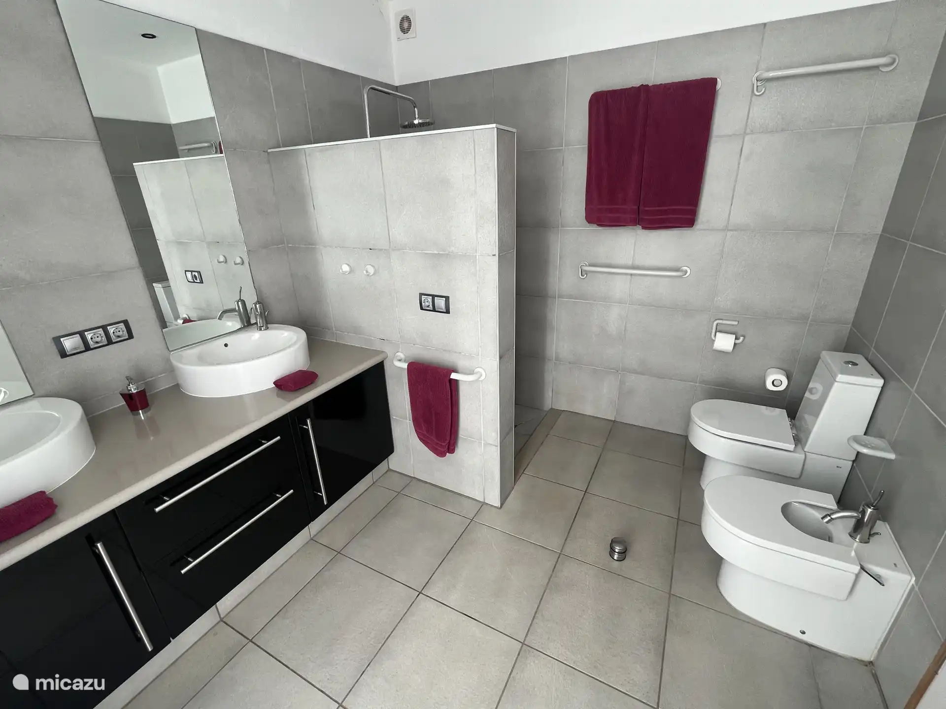 Das Badezimmer verfügt über eine sintflutartige Regendusche, zwei Waschbecken, einen Haartrockner und eine Toilette.