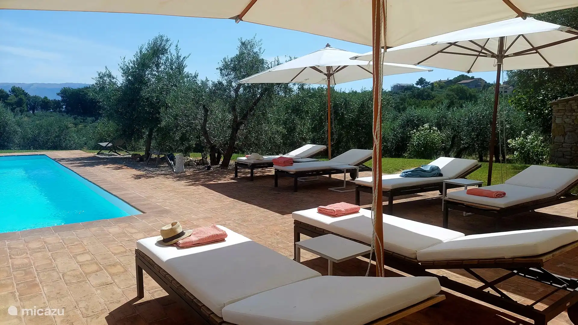 Enjoy the luxurious sunbeds by the pool with a view of the valley.