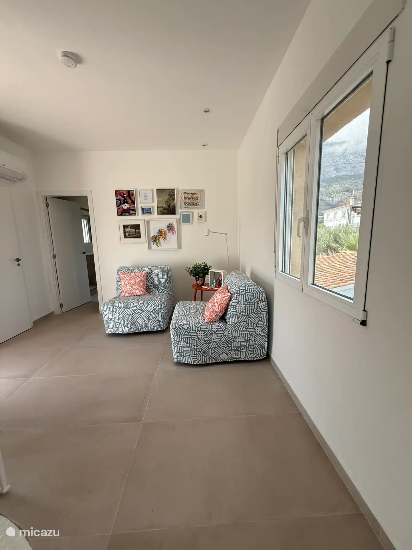 Salón de arriba con asientos, a través de la puerta de cristal se accede a la gran terraza con vistas al mar Mediterráneo y al valle del Montgó.