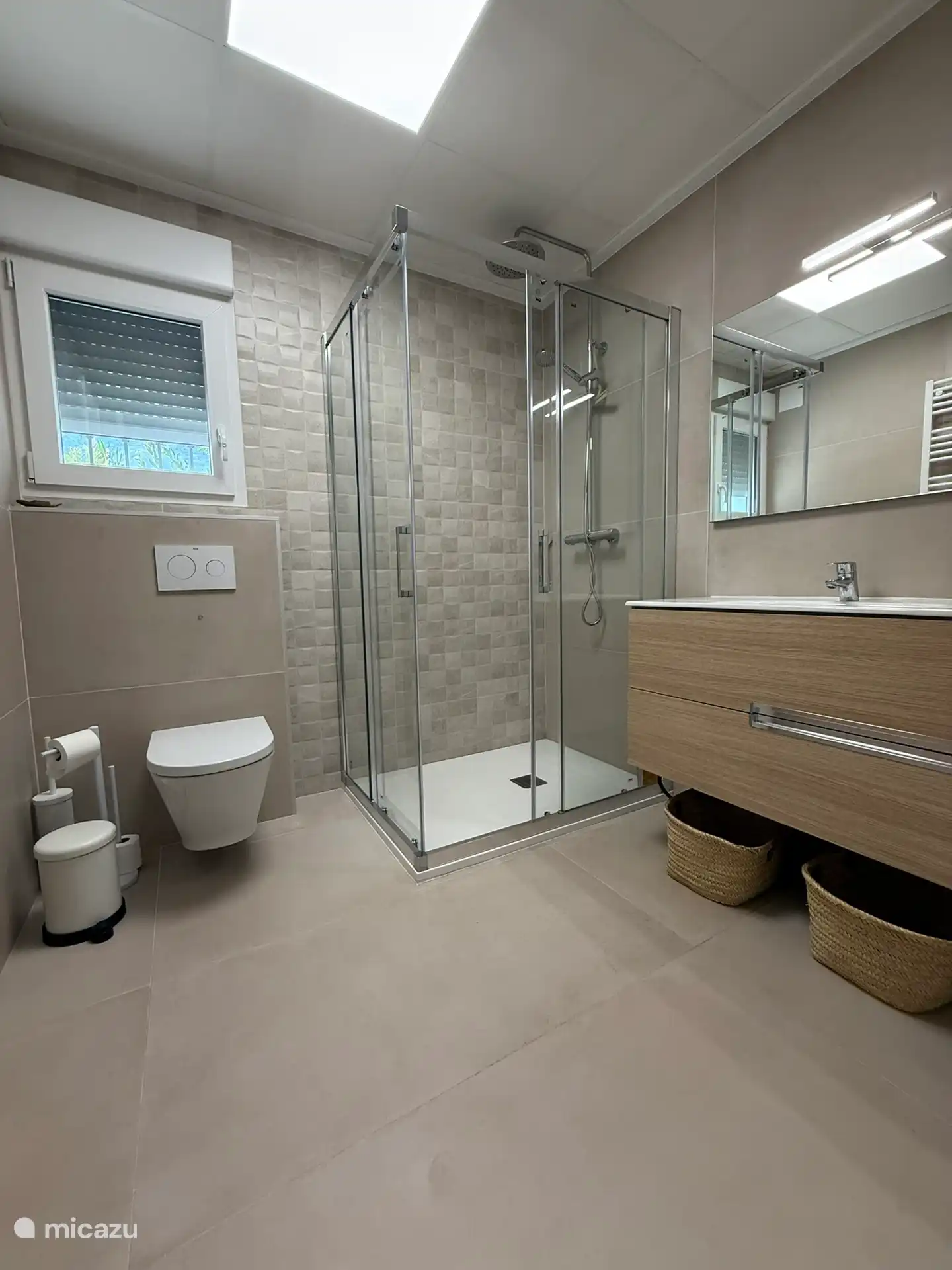 Baño planta baja. Ubicado entre 2 dormitorios con inodoro, ducha, muebles de baño y calentador de toallas.