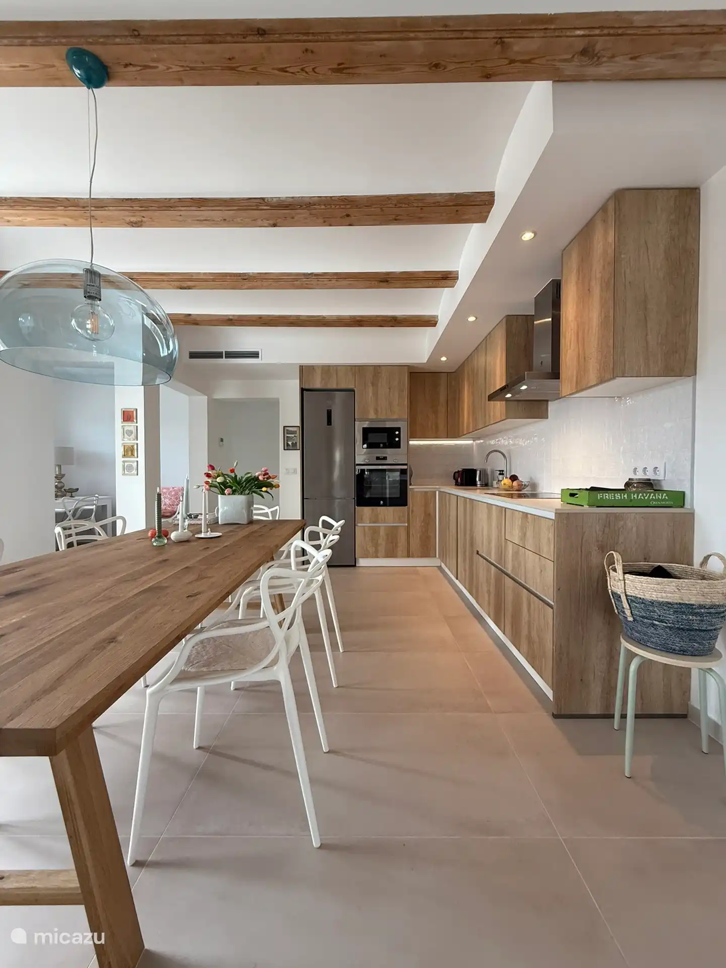 Cocina con puertas que dan al mar con vistas al Mediterráneo. Una robusta mesa de madera con 8 sillas de diseño. Todo está ahí para una deliciosa comida.