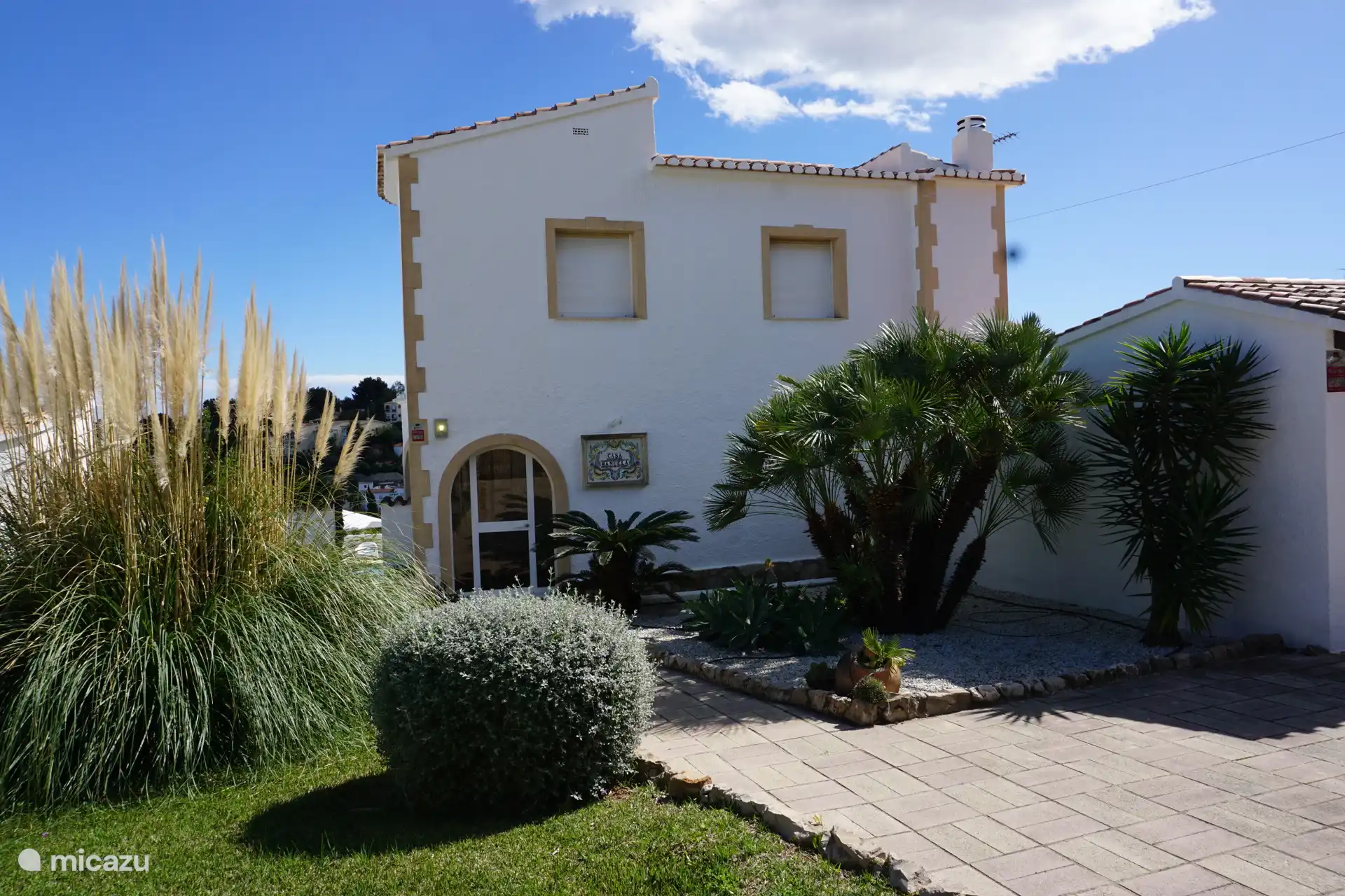 El frente de nuestra casa. La casa está rodeada por un jardín (de aproximadamente 800m2) con palmeras y árboles frutales y el aroma de hierbas y flores frescas.