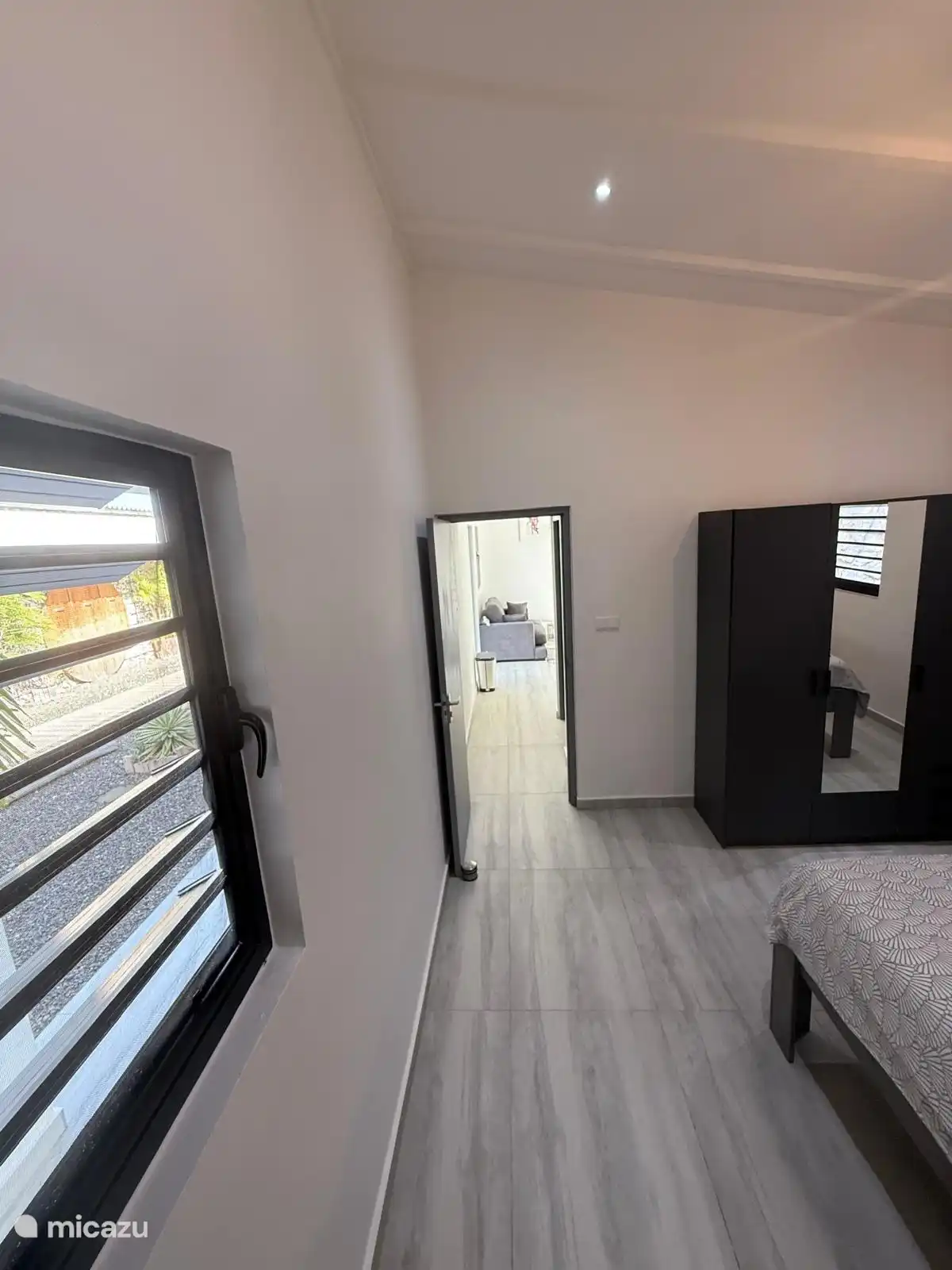 Spacious bedroom with air conditioning with wardrobe with mirror.