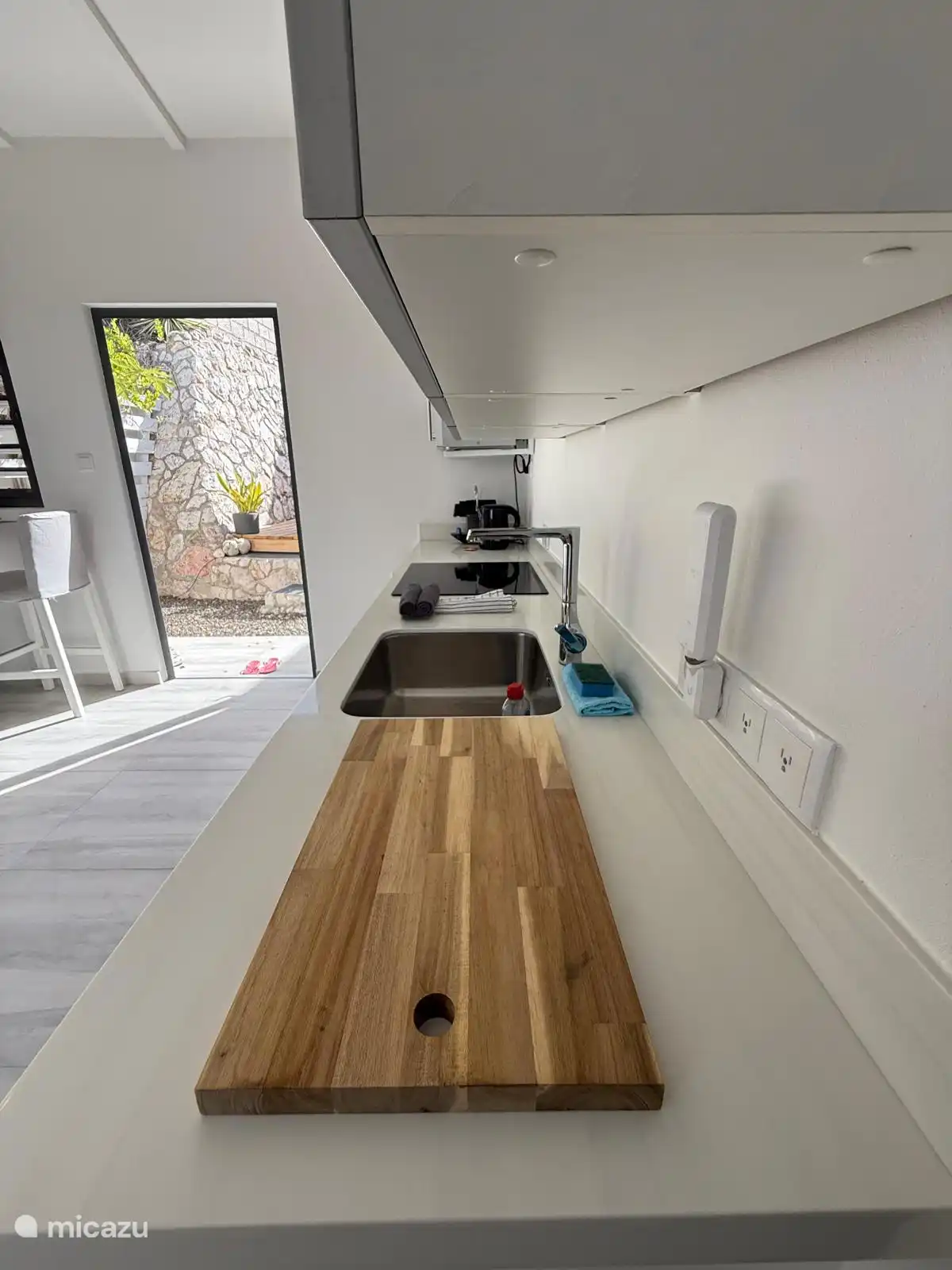 The sleek white kitchen worktop provides a fresh and elegant look, ideal for holiday comfort.