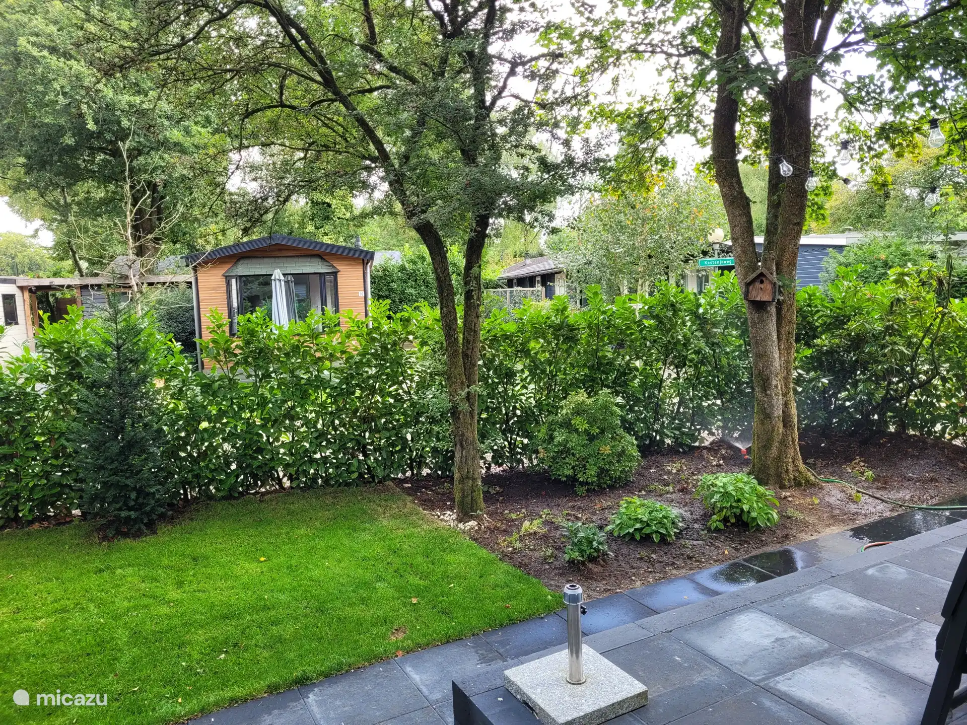 Umgeben von viel Grün und teilweise abgeschirmt für ausreichend Privatsphäre.

Schöner Garten mit Rasen, Sträuchern und Bäumen – inklusive Vogelhaus und gemütlichen Details.