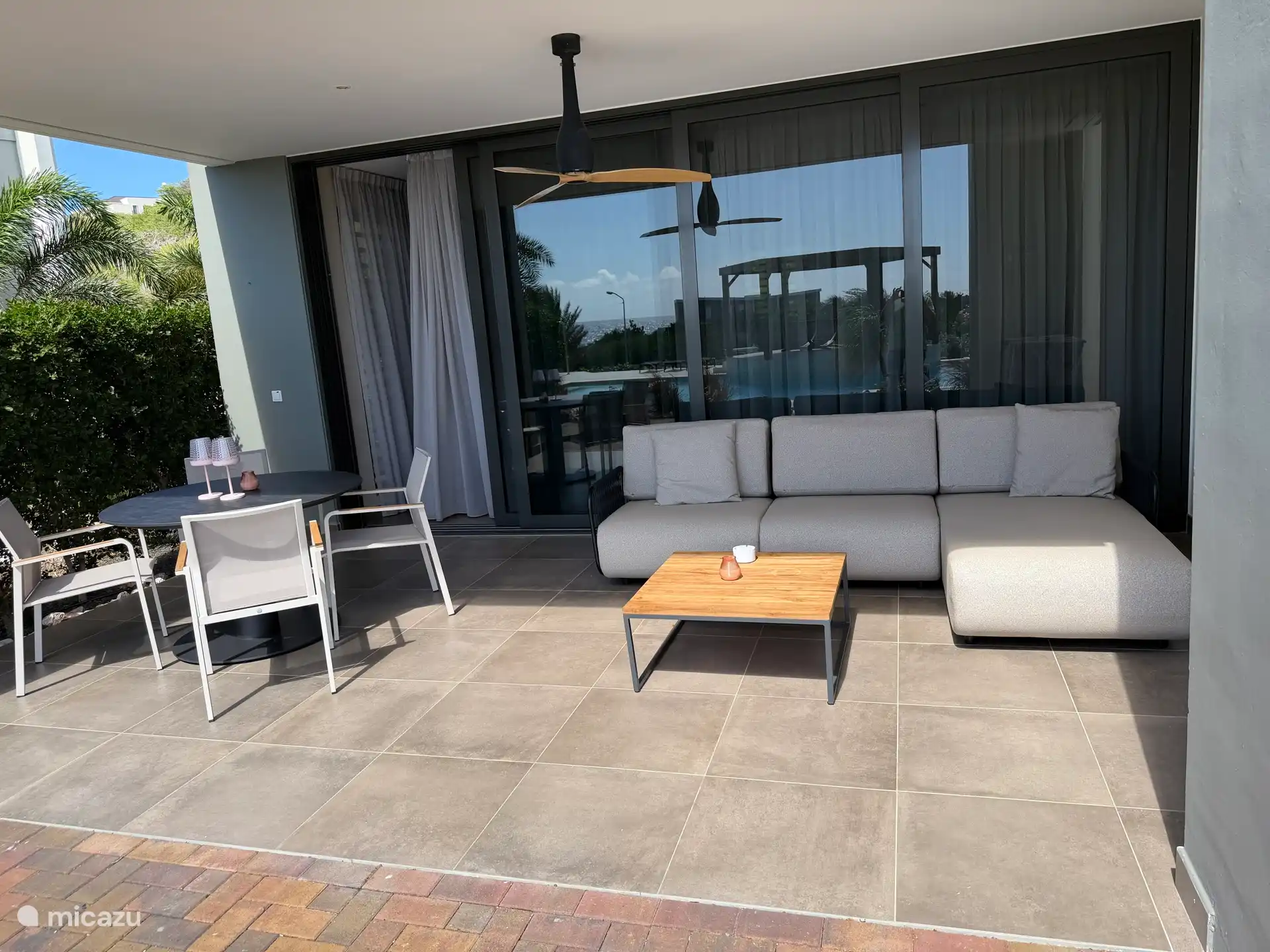 Veranda con sofá lounge y mesa de comedor