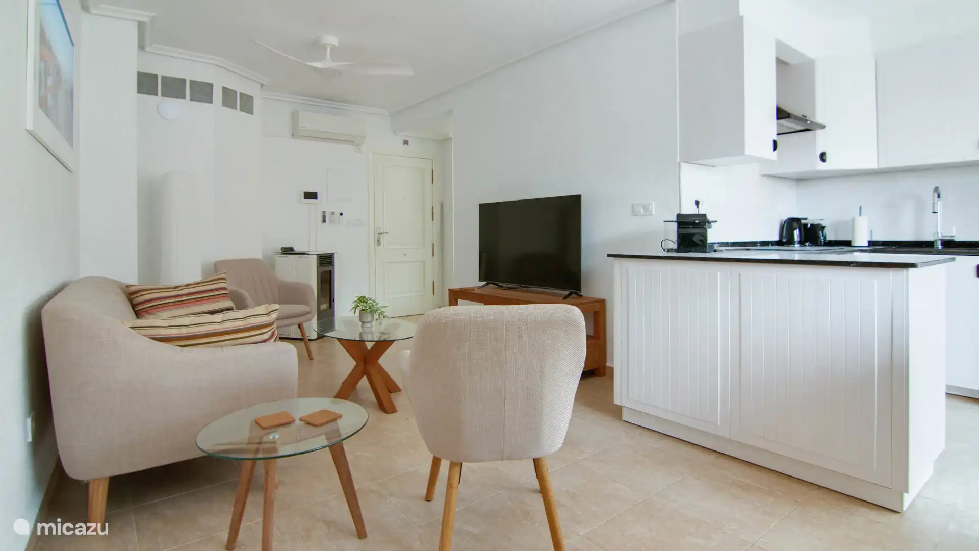 Bright living room with comfortable sitting area and open kitchen ideal for socializing.