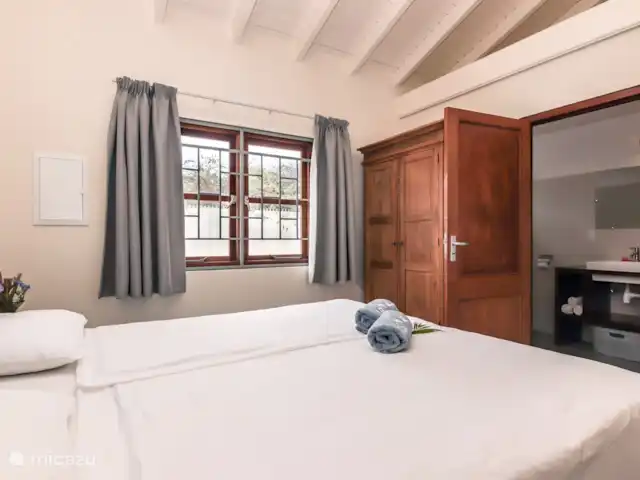 ABC Lodge Curazao B en Curazao, Curazao Centro, Julianadorp - cabaña de madera Dormitorio con ventanas francesas y baño contiguo