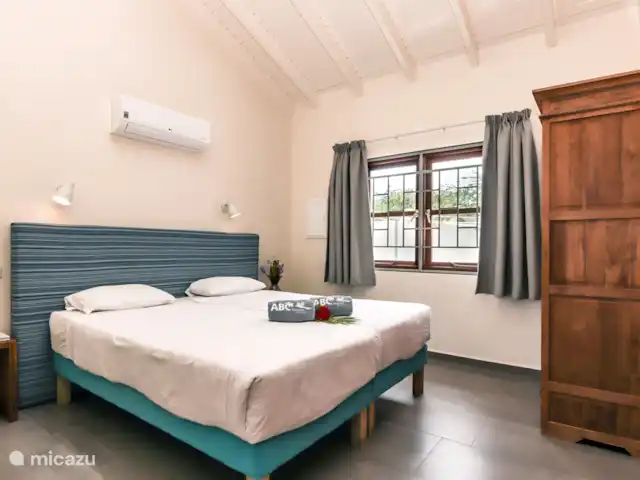 ABC Lodge Curazao B en Curazao, Curazao Centro, Julianadorp - cabaña de madera Dormitorio con aire acondicionado y un armario con estantes y espacio para colgar