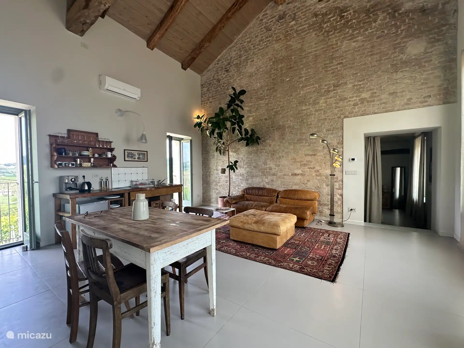 Sala de estar con cocina americana y cómodos sofás para disfrutar de las vistas.