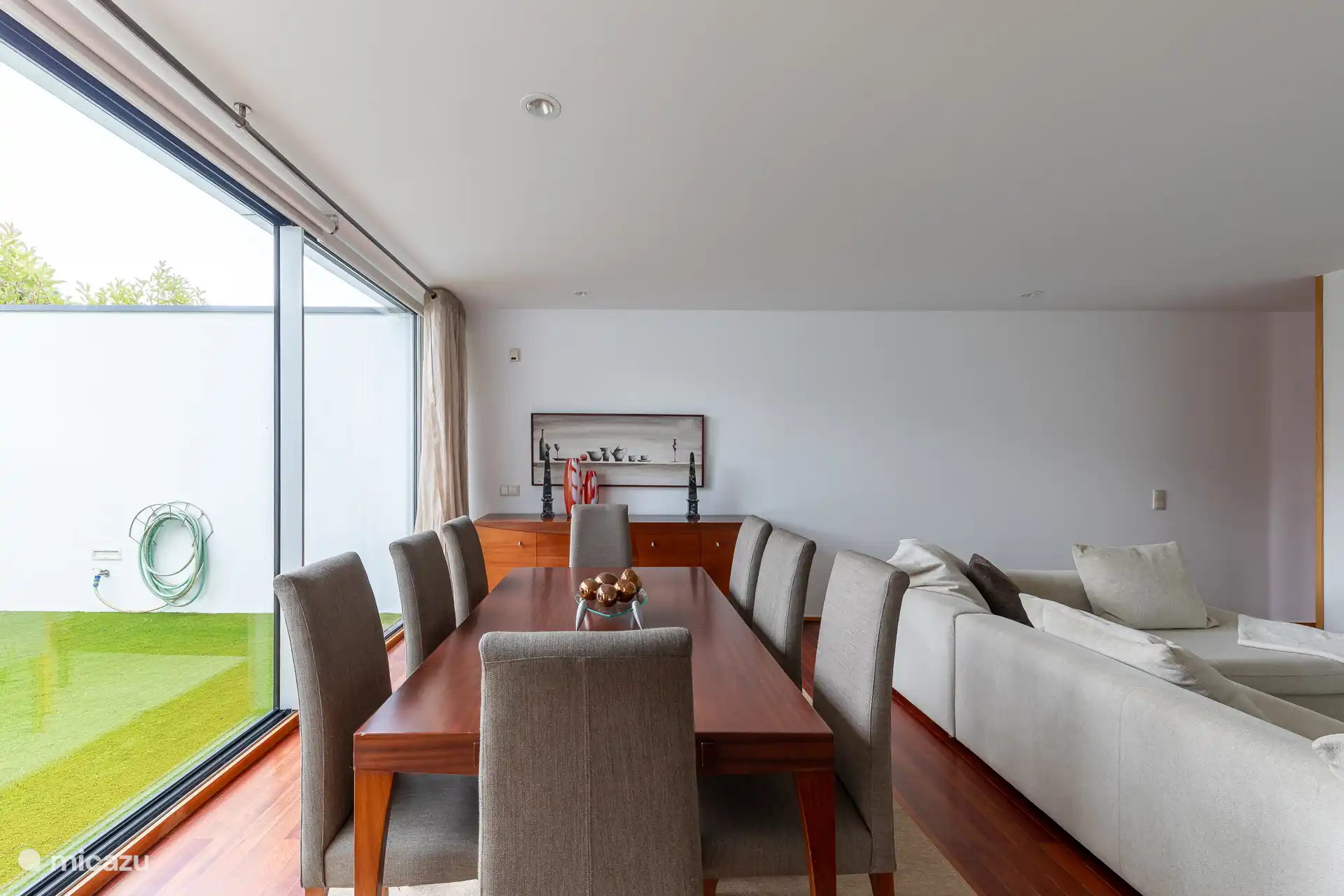 Geräumiges Interieur im Wohnzimmer mit einem Esstisch, einem gemütlichen Sofa und einem TV mit einer großen Auswahl an Kabelkanälen.