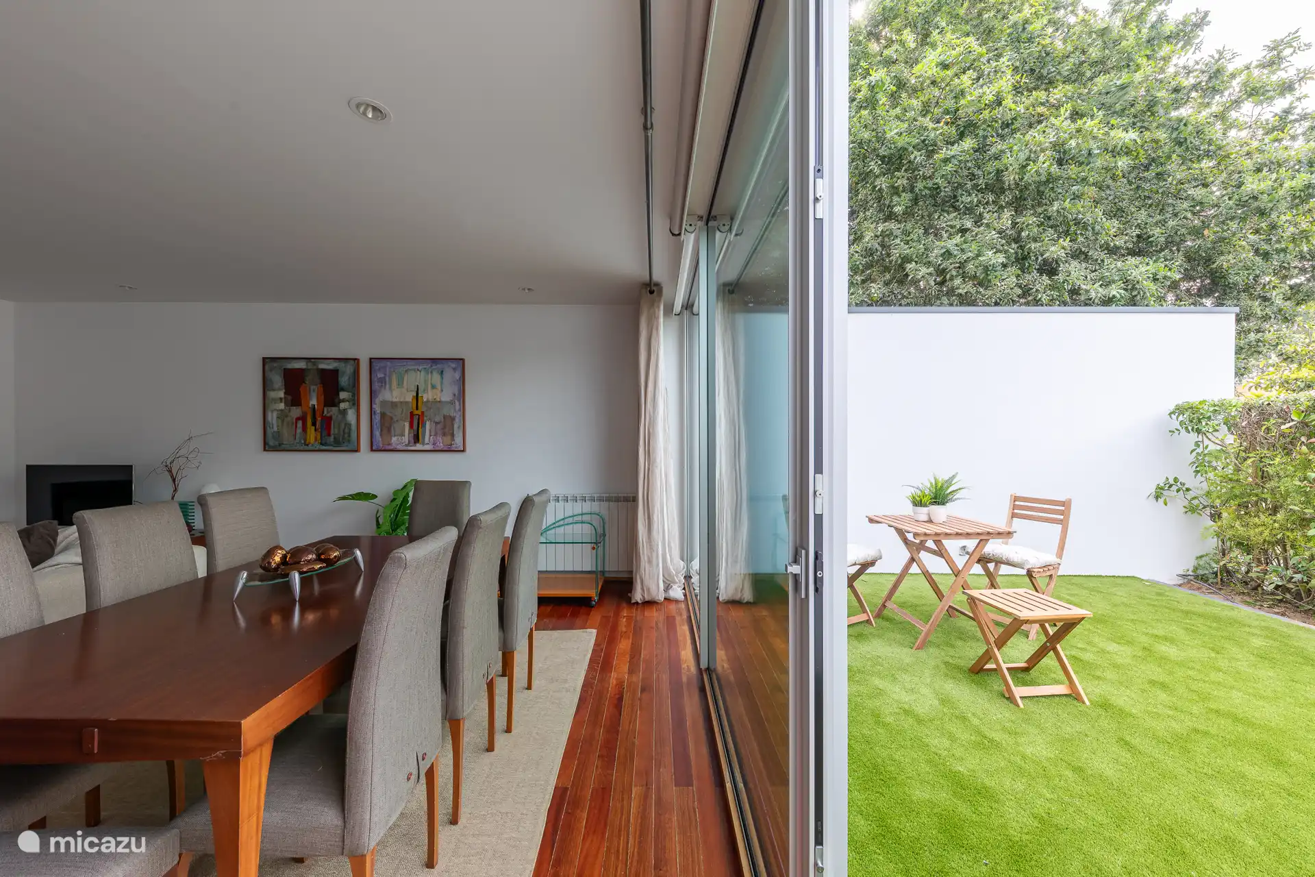 Geräumiges Interieur im Wohnzimmer mit einem Esstisch, einem gemütlichen Sofa und einem TV mit einer großen Auswahl an Kabelkanälen.