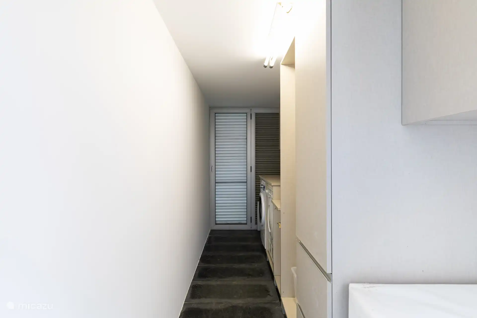 Gut ausgestatteter Hauswirtschaftsbereich mit Waschmaschine, Trockner und einem modernen Elektrogrill für Ihren Komfort.