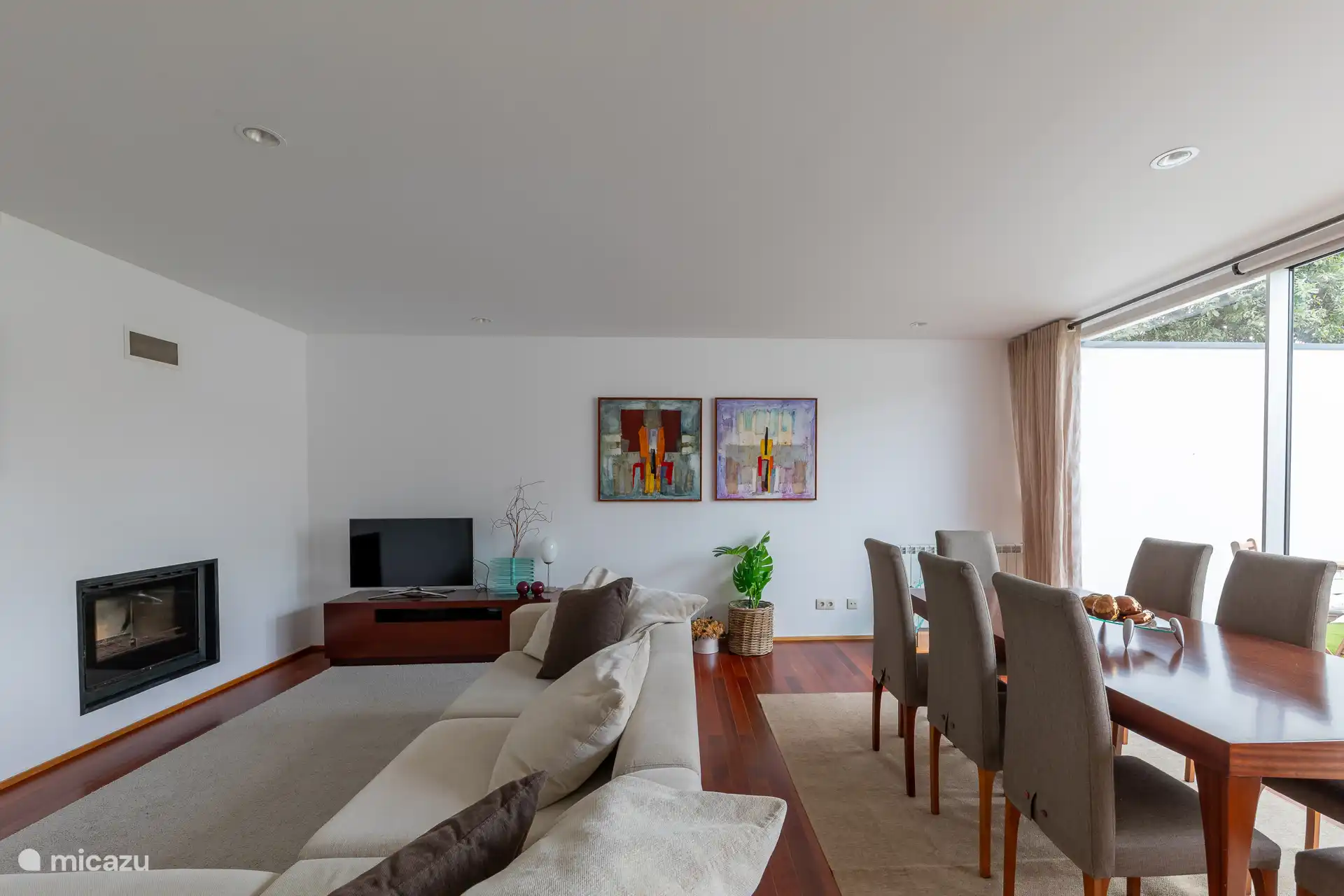 Geräumiges Interieur im Wohnzimmer mit einem Esstisch, einem gemütlichen Sofa und einem TV mit einer großen Auswahl an Kabelkanälen.