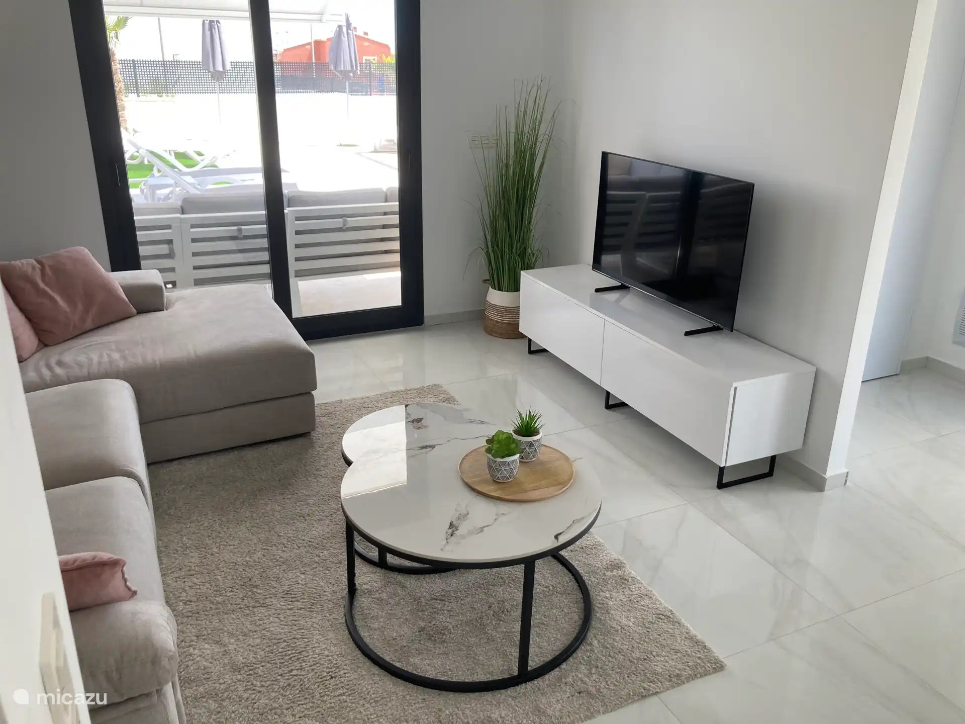 Open plan living room with large corner lounge, smart TV with chromecast