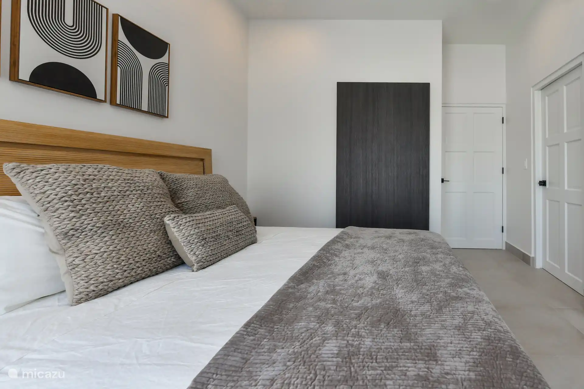 Schlafzimmer mit Kingsize-Bett, TV, Klimaanlage und Poolblick