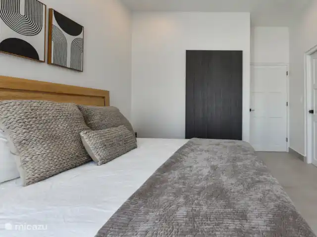 Casa Ruby con piscina privada en Aruba, Norte, Noord - casa vacacional Dormitorio con cama King size, TV, aire acondicionado y vista a la piscina