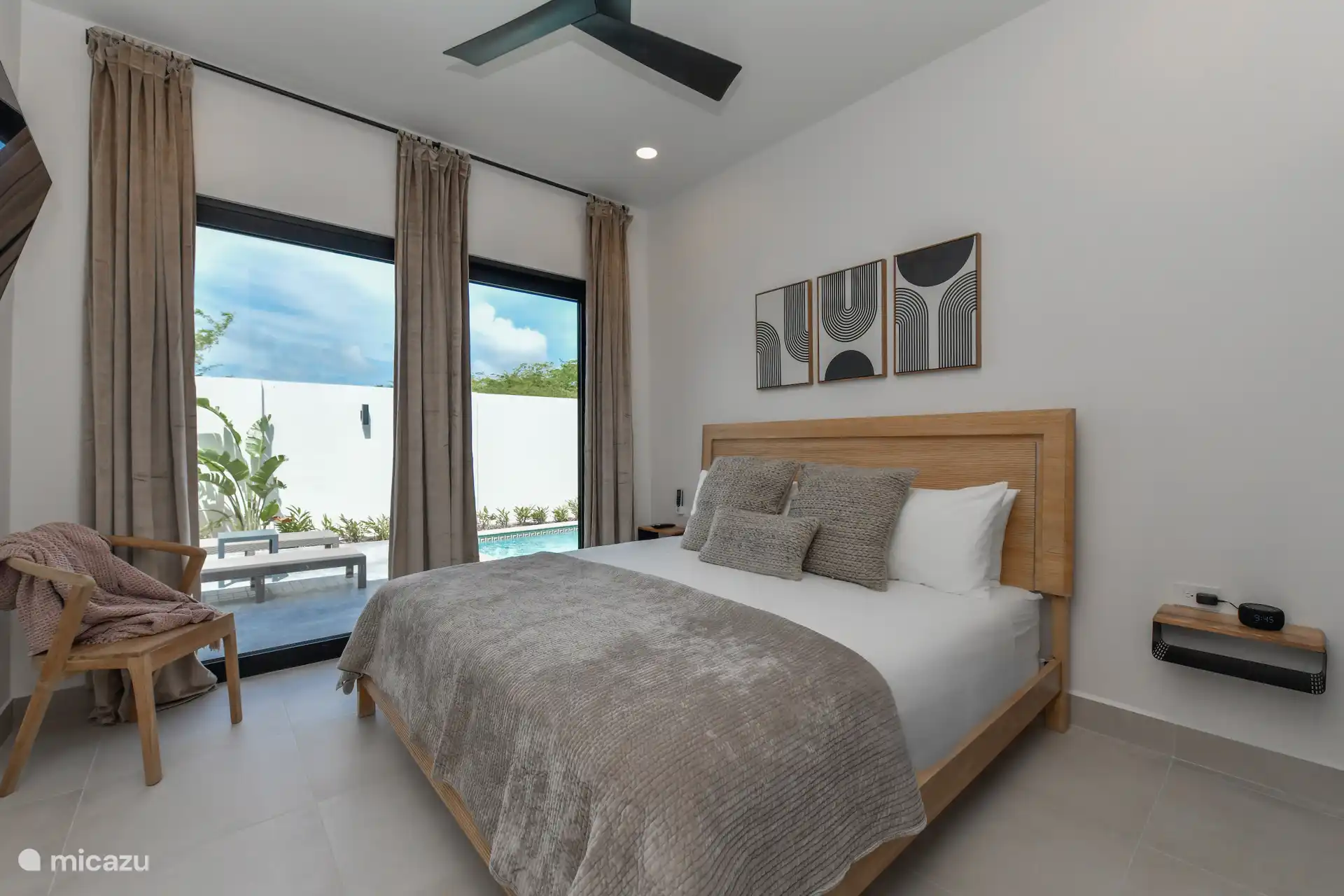 Schlafzimmer mit Kingsize-Bett, TV, Klimaanlage und Poolblick