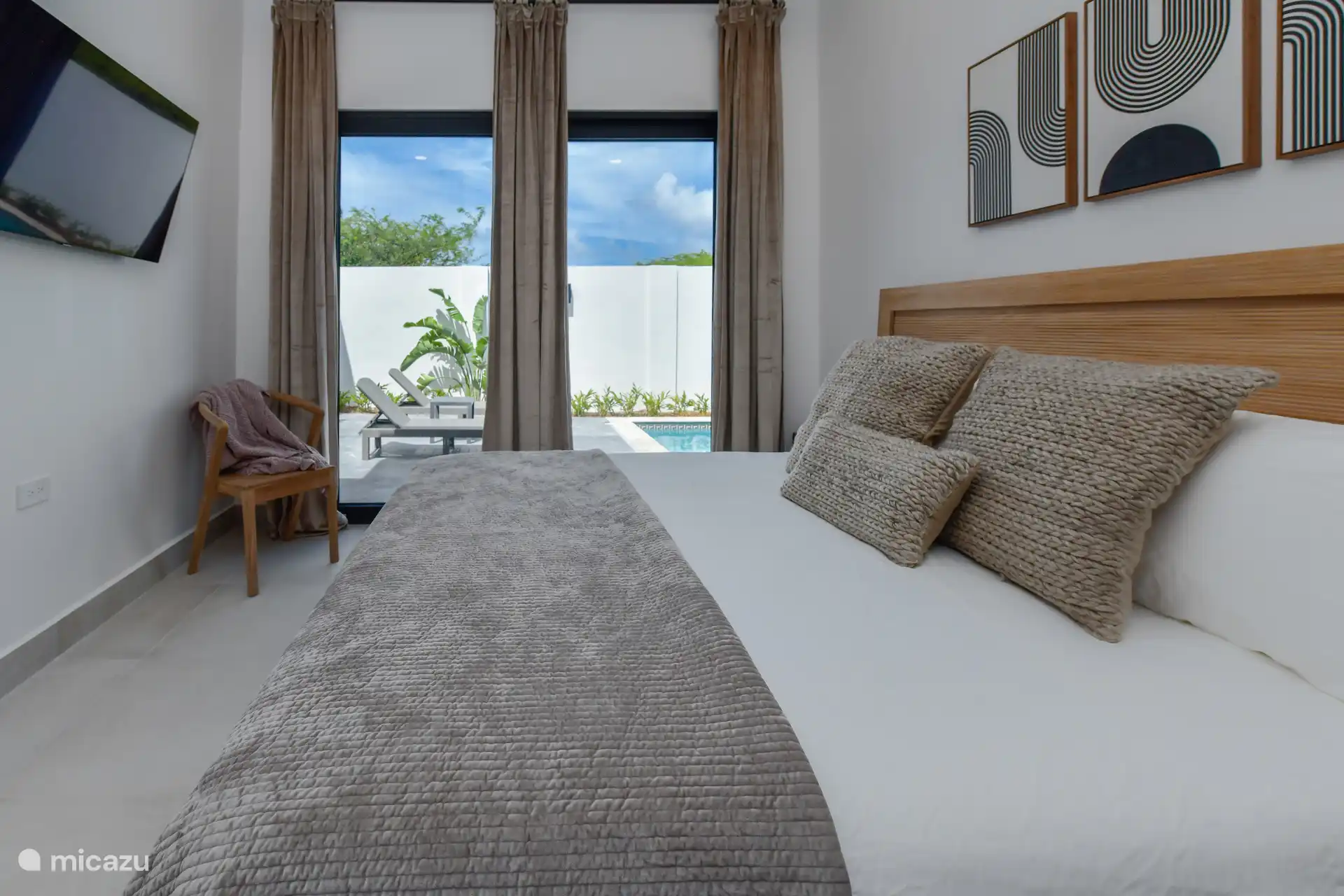 Schlafzimmer mit Kingsize-Bett, TV, Klimaanlage und Poolblick