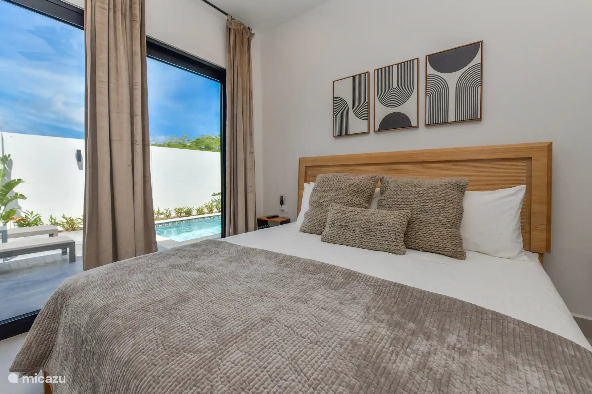 Schlafzimmer mit Kingsize-Bett, TV, Klimaanlage und Poolblick