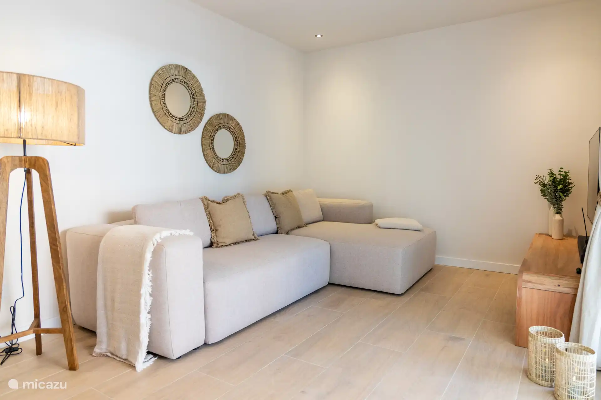 Geräumiges Ecksofa mit TV und Blick auf die Terrasse.