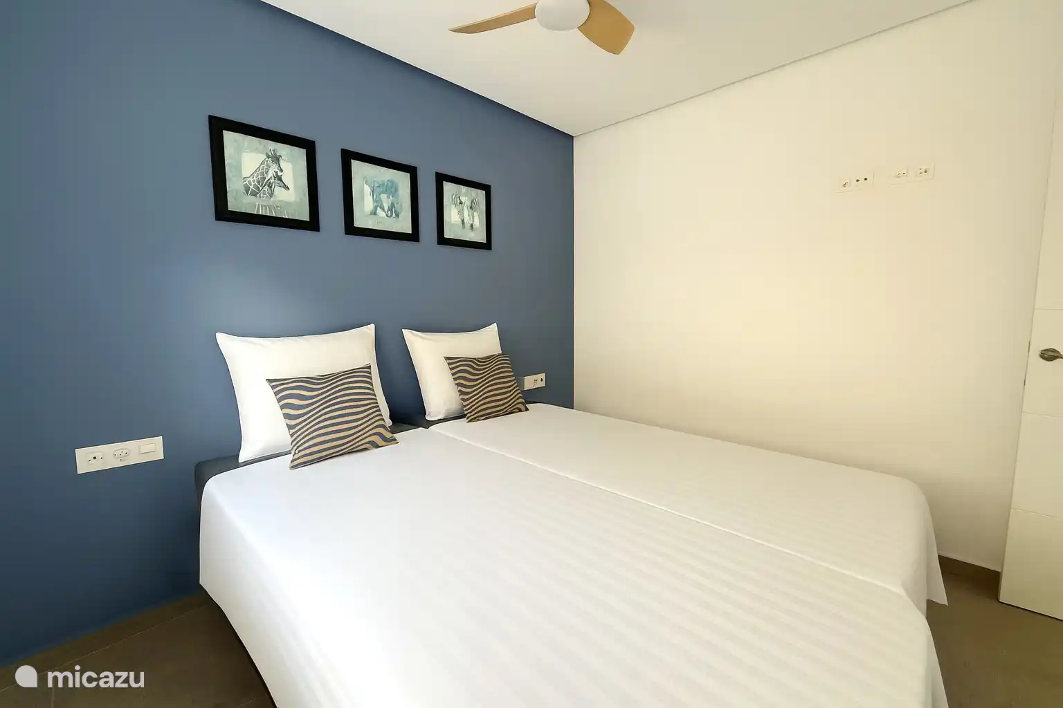 Schlafzimmer mit Klimaanlage, Ventilator und großem Schiebeschrank