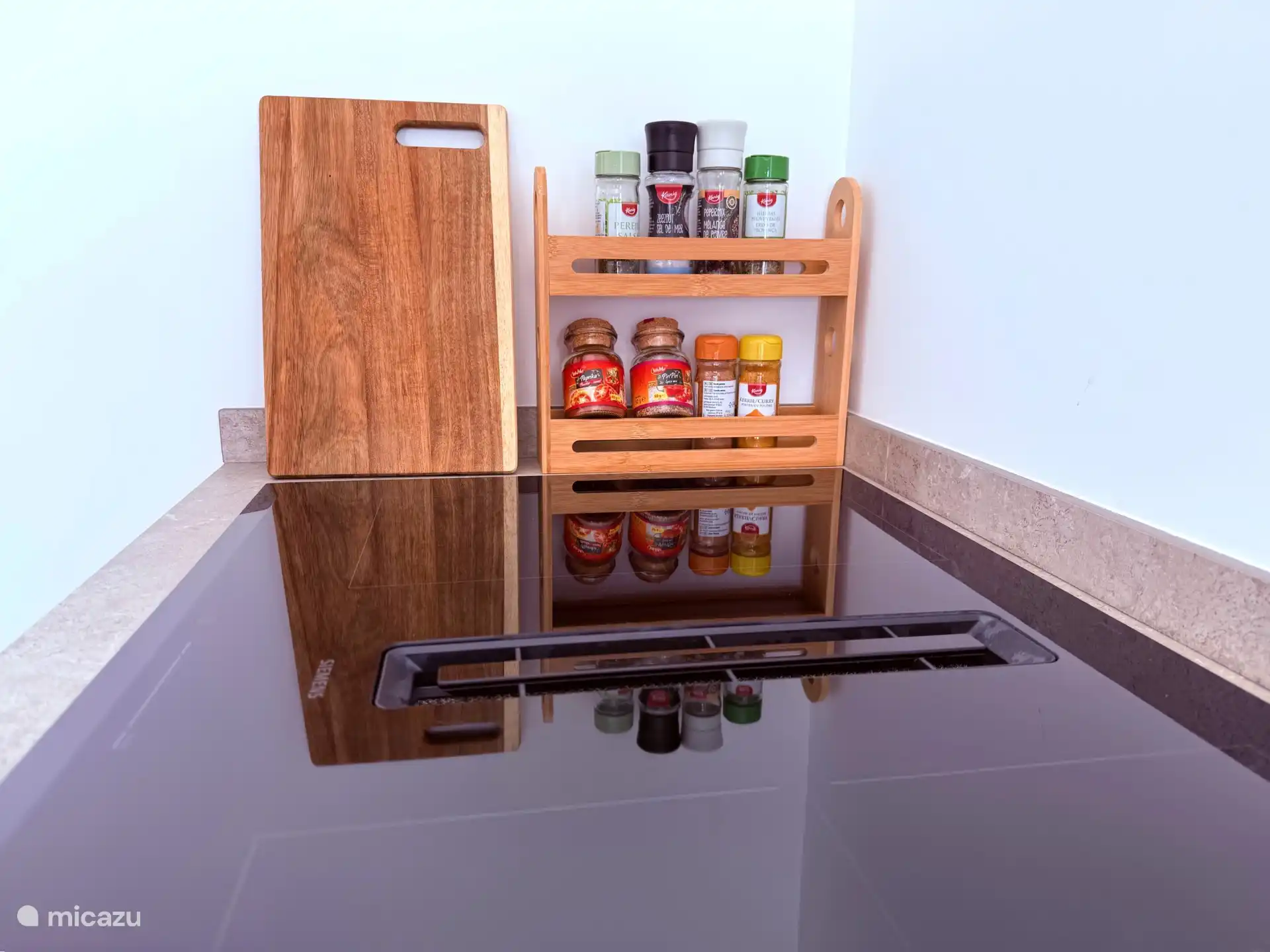 Gewürzregal mit essentiellen Gewürzen und Induktionskochfeld mit Dunstabzug