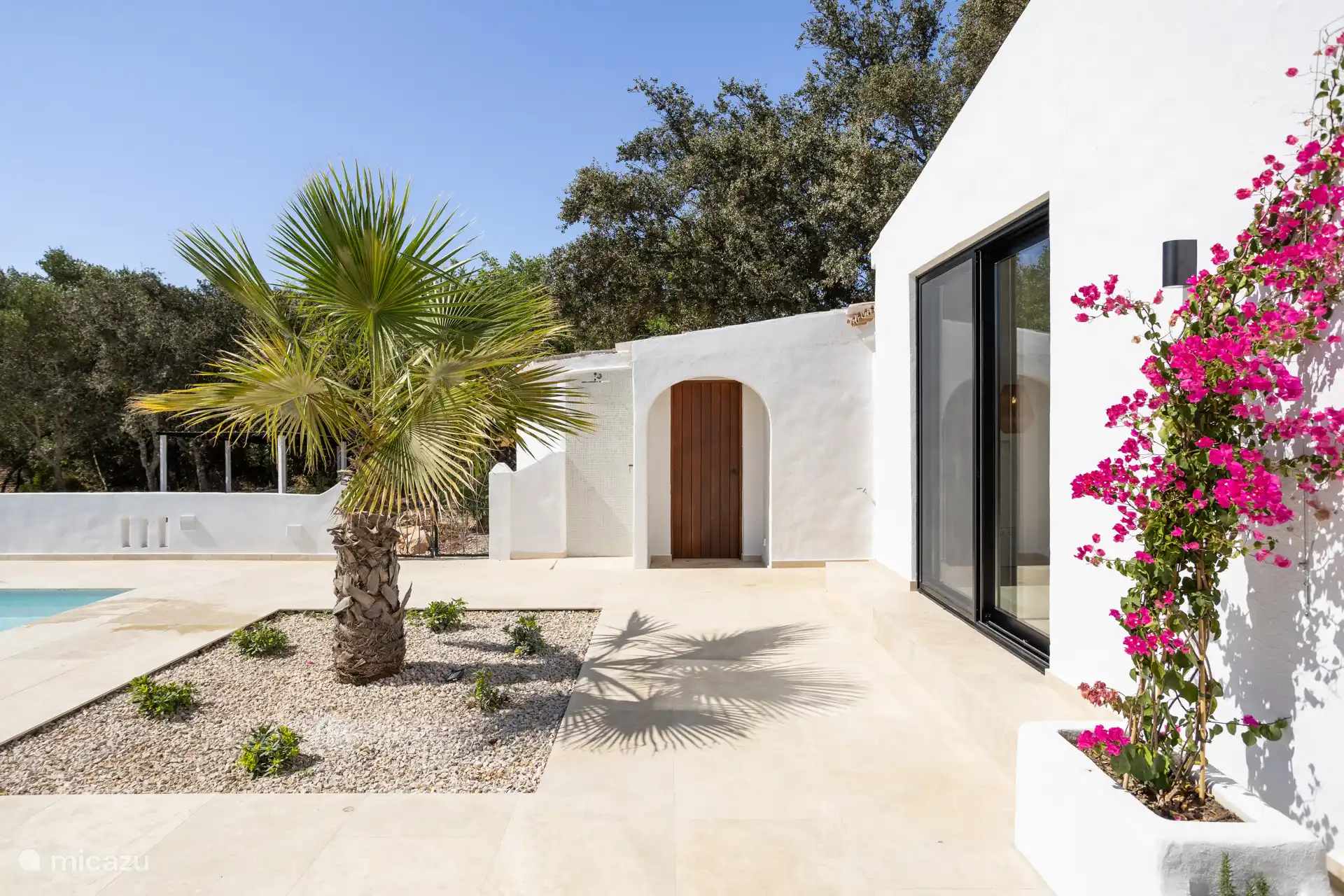 Cuando conduce por el camino de entrada, en realidad conduce por el costado hasta la parte trasera del estacionamiento. Aquí se entra con una pequeña escalera a través de la piscina donde también hay un anexo.