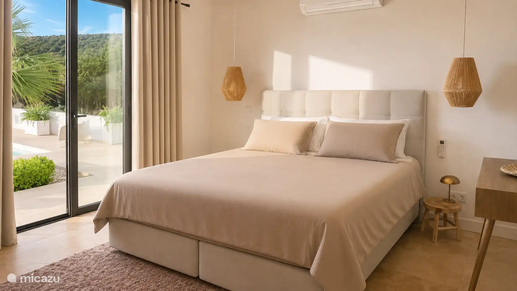 De master in het basishuis met uitzicht op de palmboom en het zwembad. Het openkomende zonnetje maakt je wakker