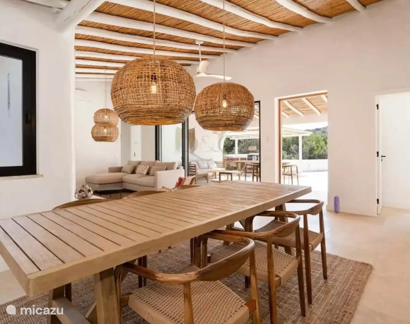 Desde la cocina abierta se mira a través de la puerta corredera, que se puede abrir en todo el ancho, a la cocina exterior. ¡El estilo ibicenco se siente en todas partes!