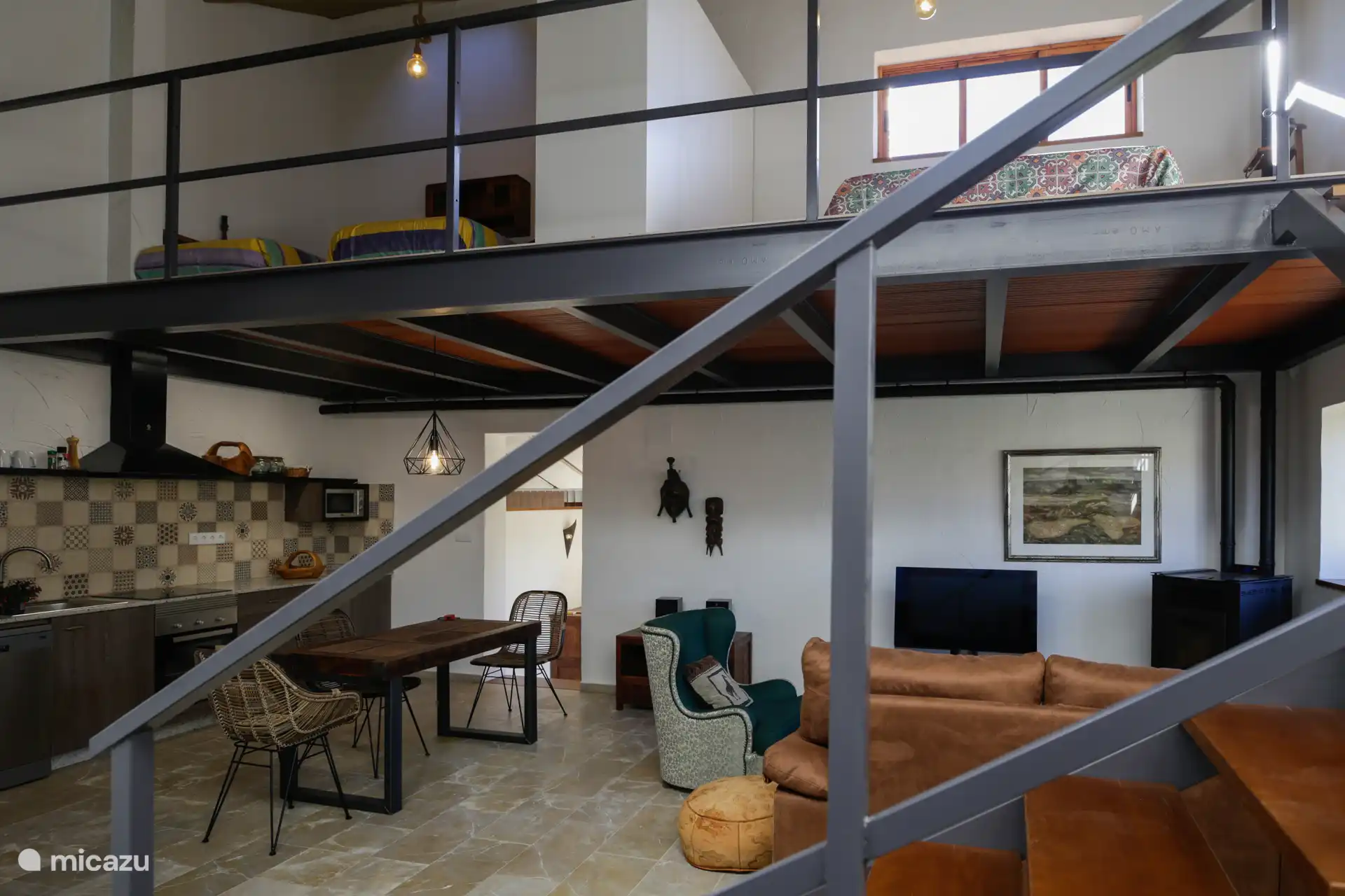 Uitzicht op de hoofdruimte vanaf de pergola, je kunt de woonkamer, eetkamer en keuken zien. En de bovenkamer.