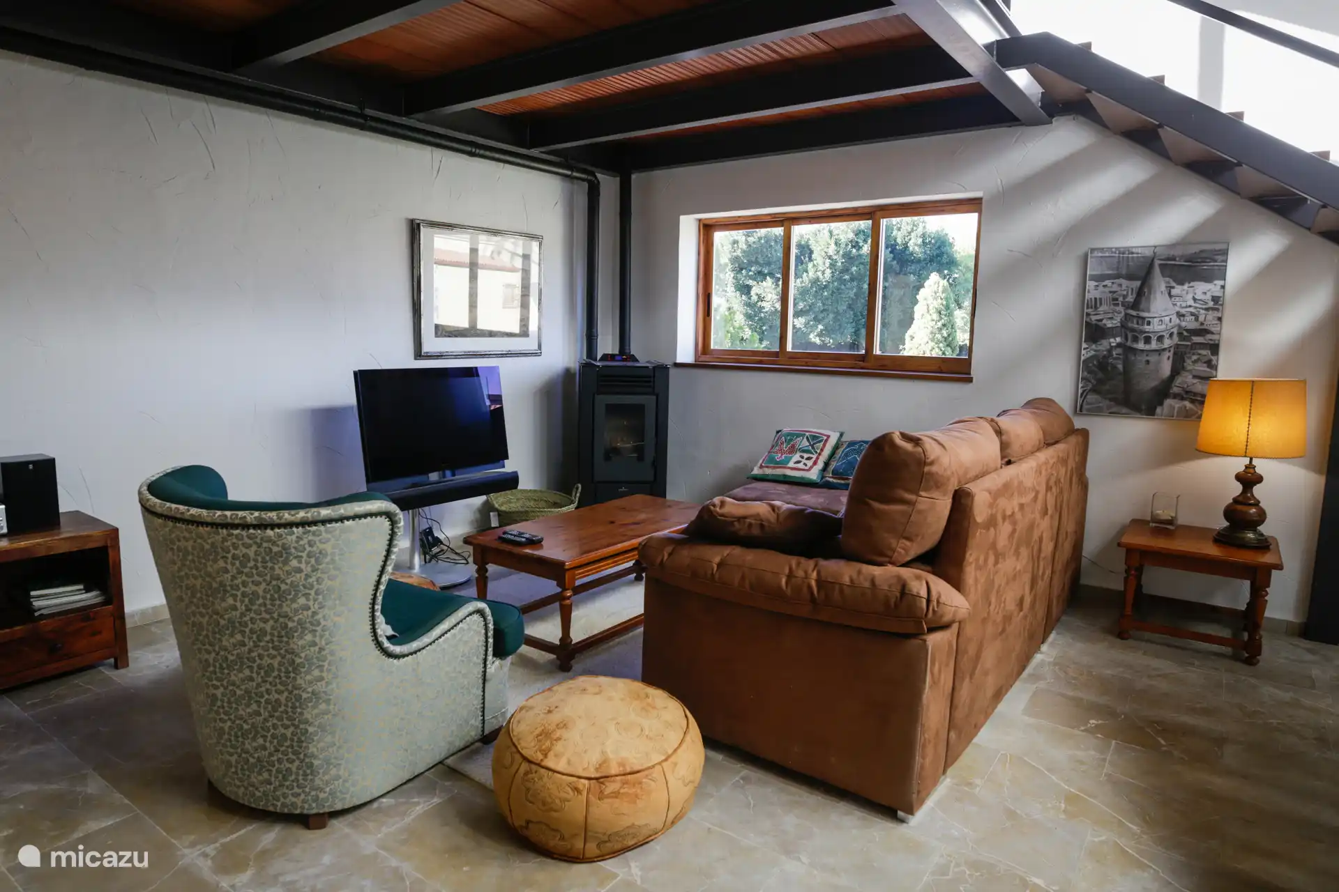 Uitzicht op een deel van de woonkamer, woonkamer. Op de achtergrond de pelletopen haard die de kamer verwarmt.