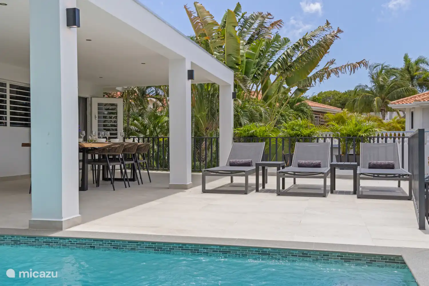 De beaux transats au bord de la piscine