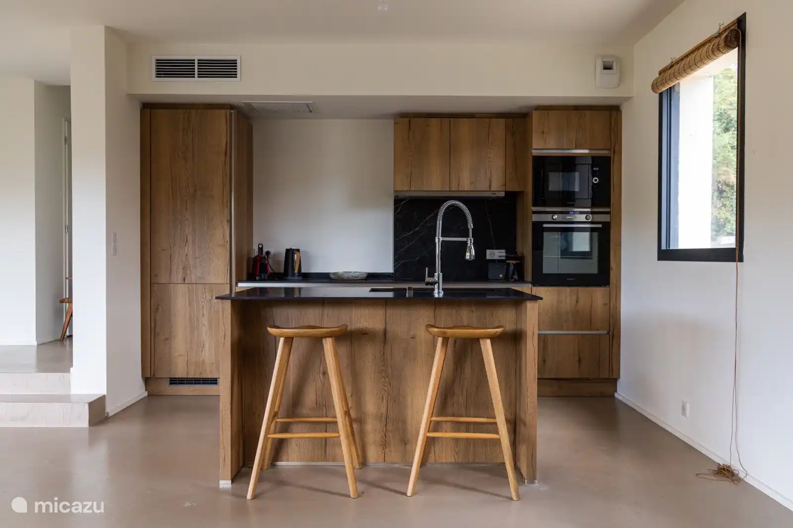 Die Kücheninsel verfügt über eine Bar für einen schnellen Happen oder ein schönes Glas Wein während des Kochens. 