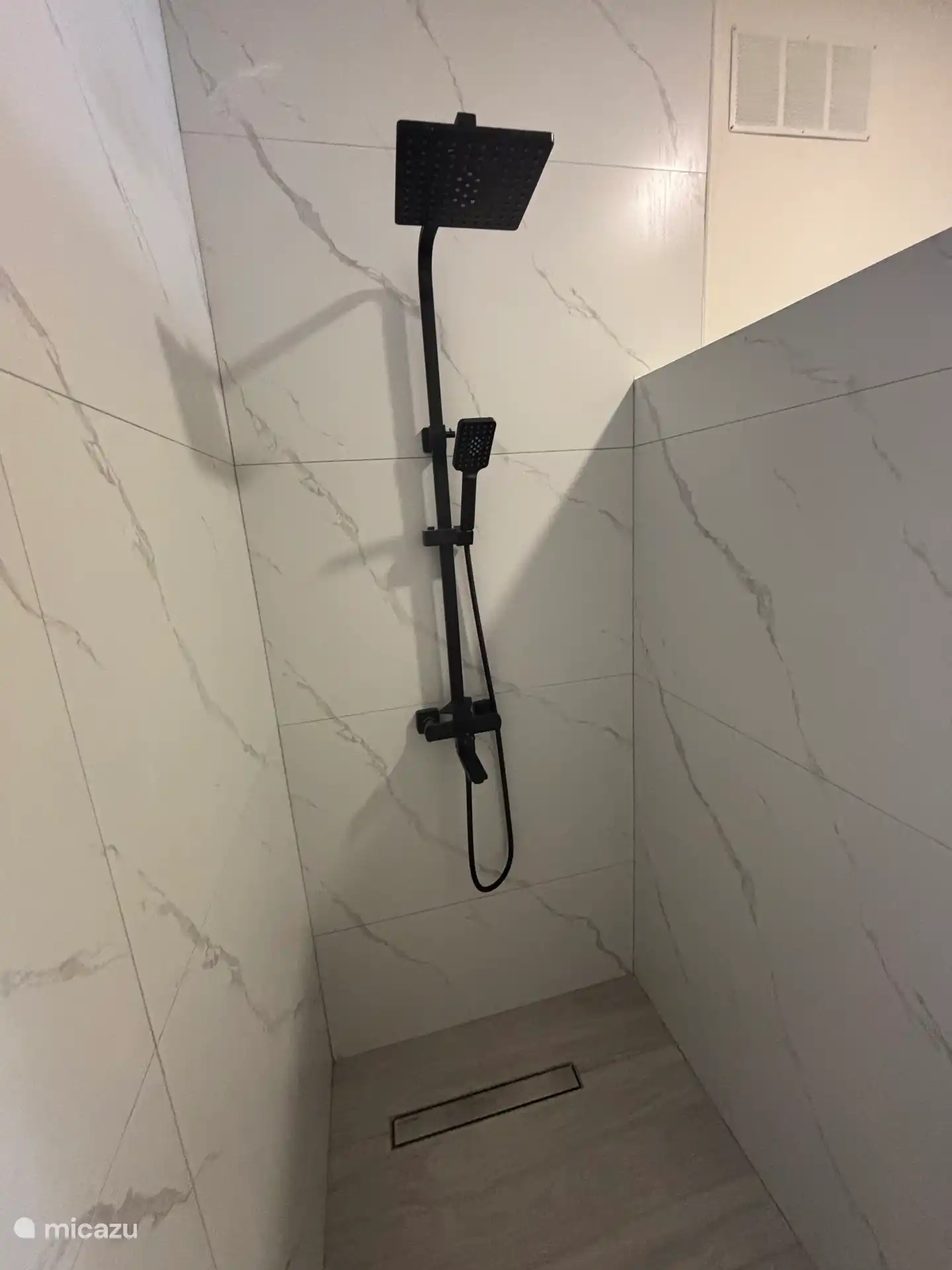 Begehbare Dusche mit modernem Duschkopf. Perfekt, um sich zu einem tollen Strandtag abzukühlen. 