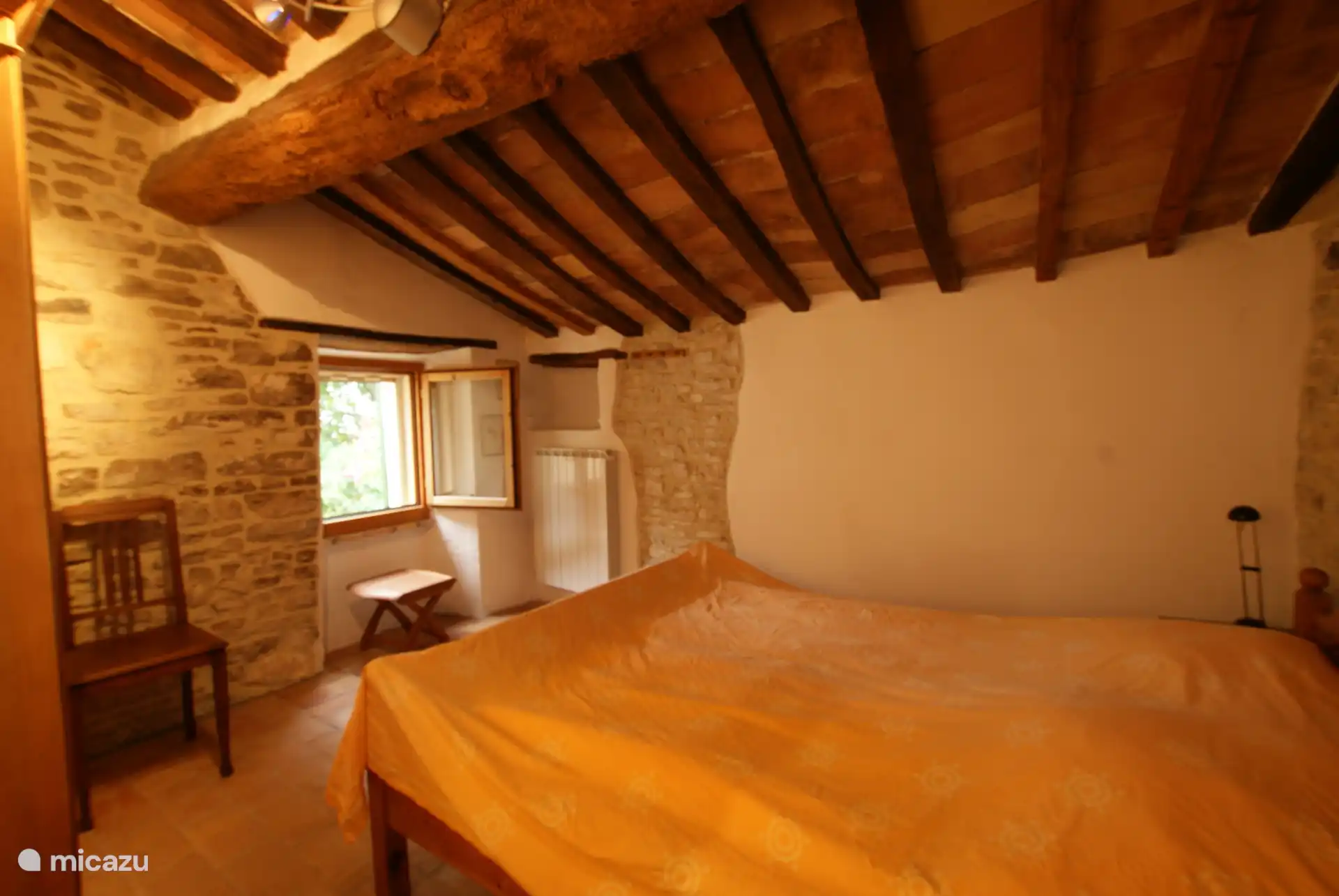 Schlafzimmer 2, Doppelbett, Natursteinwand, Fenster zum Garten mit weiter Sicht bis Avacelli.