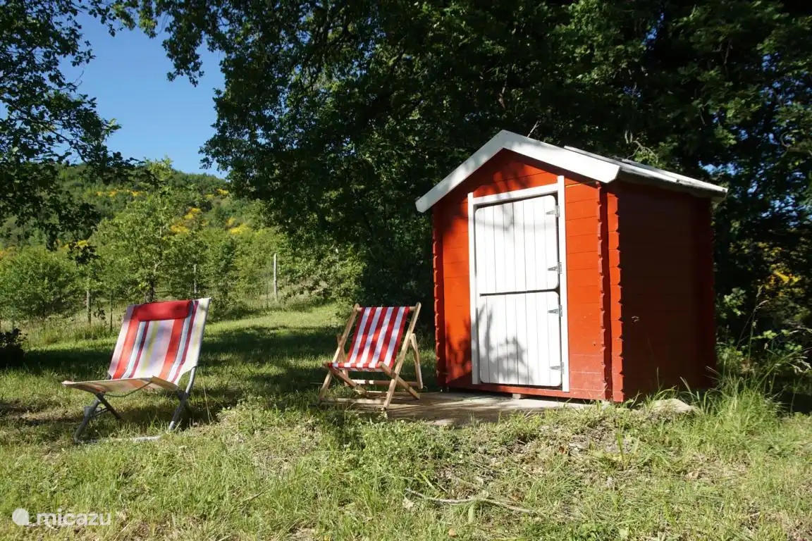 Kinderspielhaus mit kleinen Liegenstühlen für Kinder im Garten