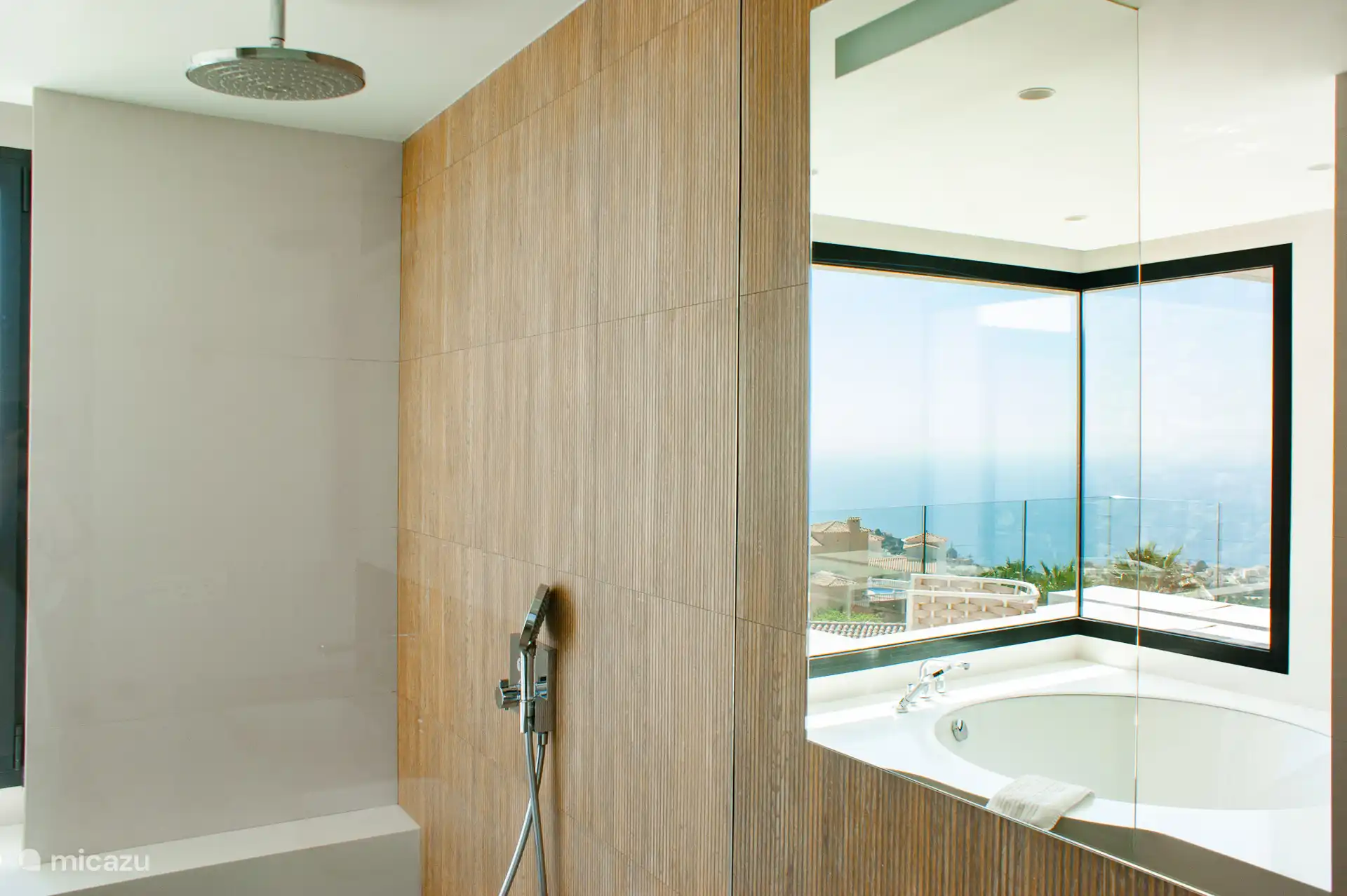 Badezimmer mit zwei Waschbecken, Toilette, begehbare Dusche, Badewanne und wunderschöner Aussicht