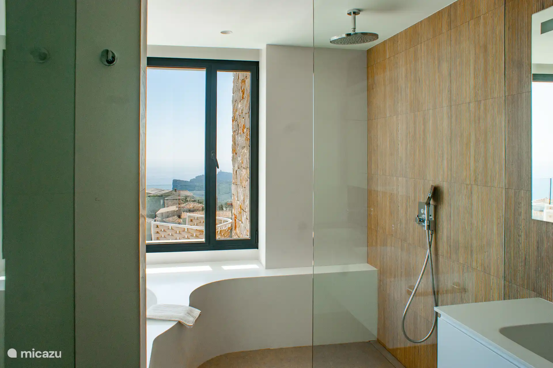 Badezimmer mit zwei Waschbecken, Toilette, begehbare Dusche, Badewanne und wunderschöner Aussicht