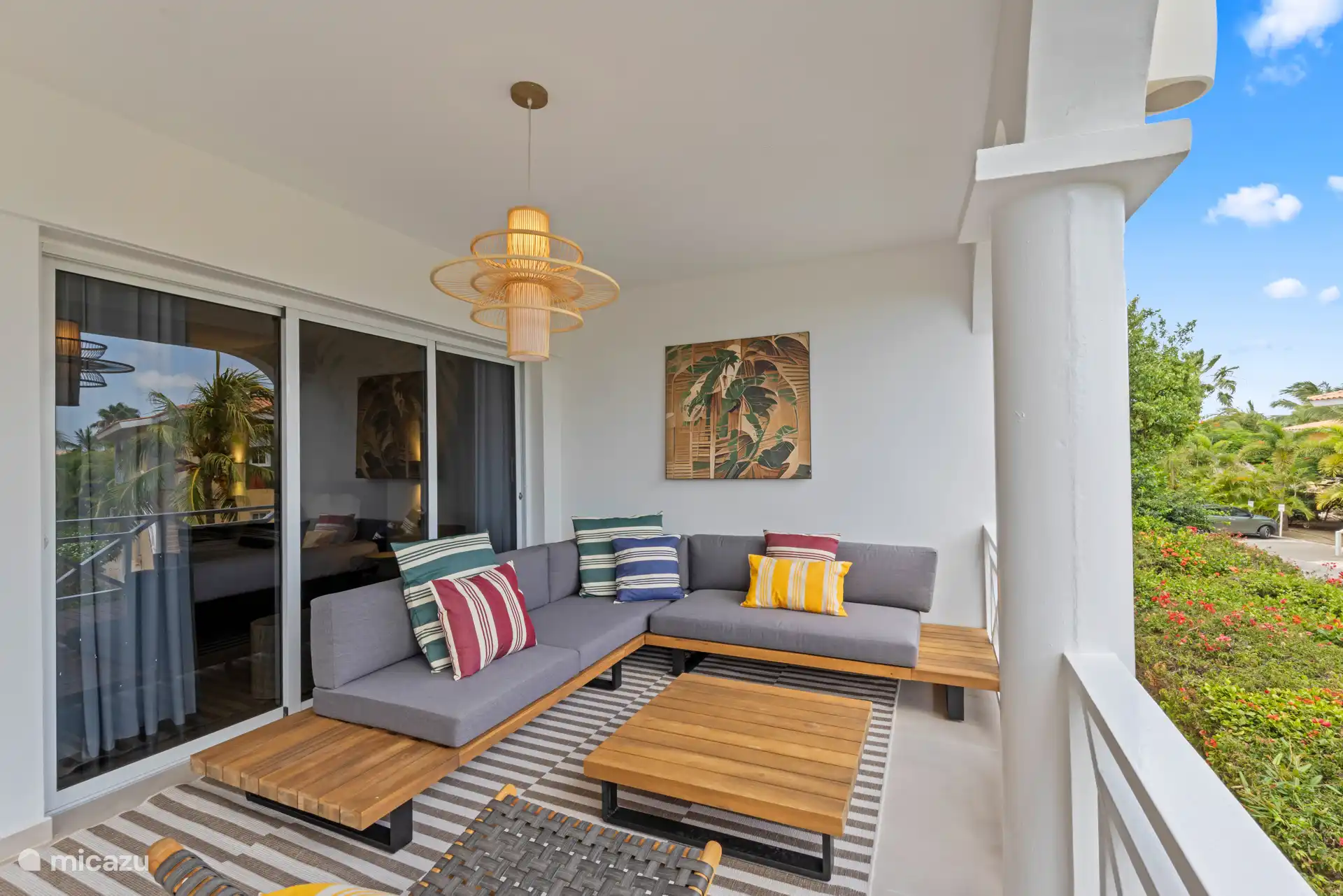 Zona de salón en la terraza con vistas al jardín y a las montañas.