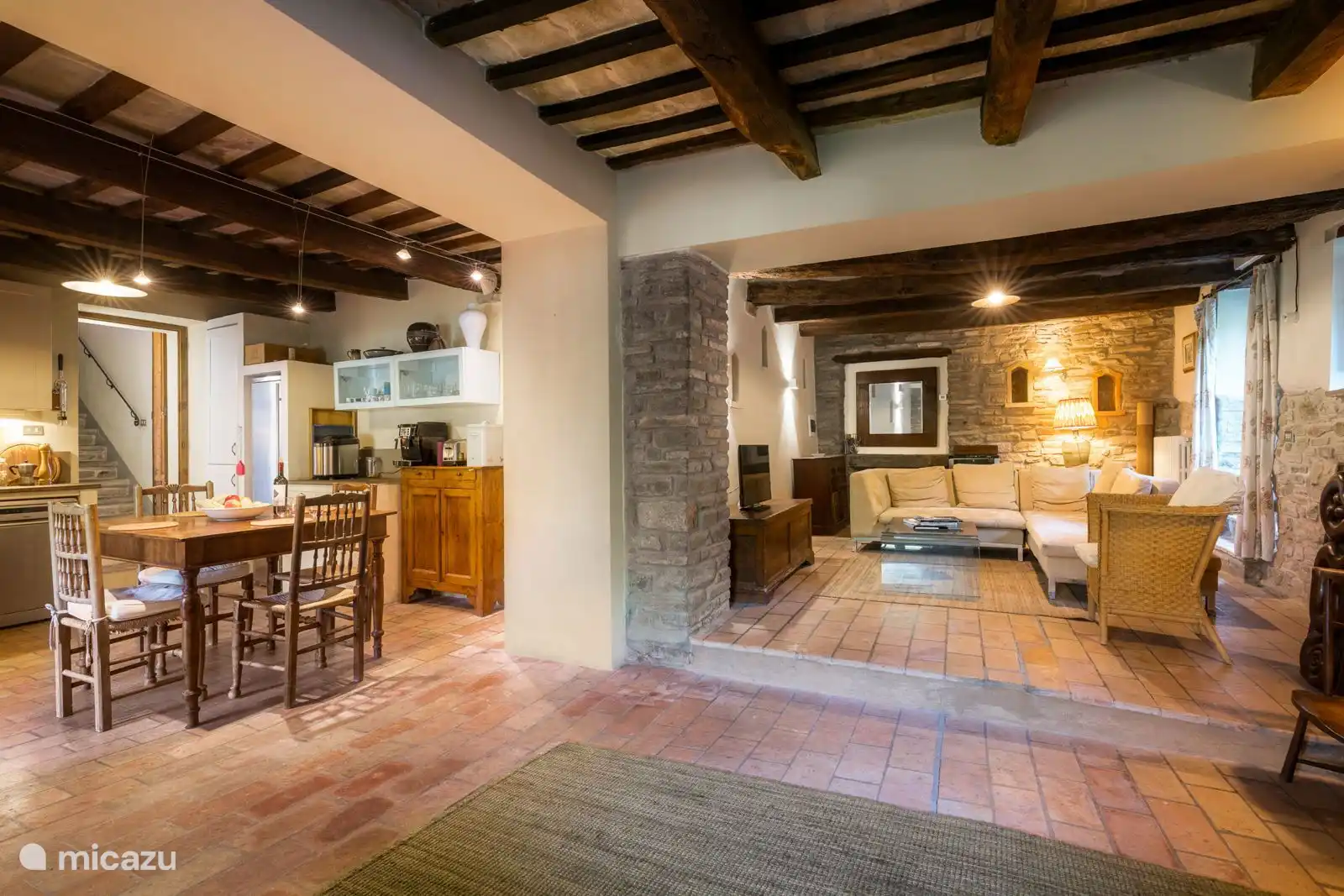 The villa's living room is the perfect cozy retreat. It features a spacious sofa, a lovely fireplace for cold seasons, and is connected to the kitchen for easy socialising.