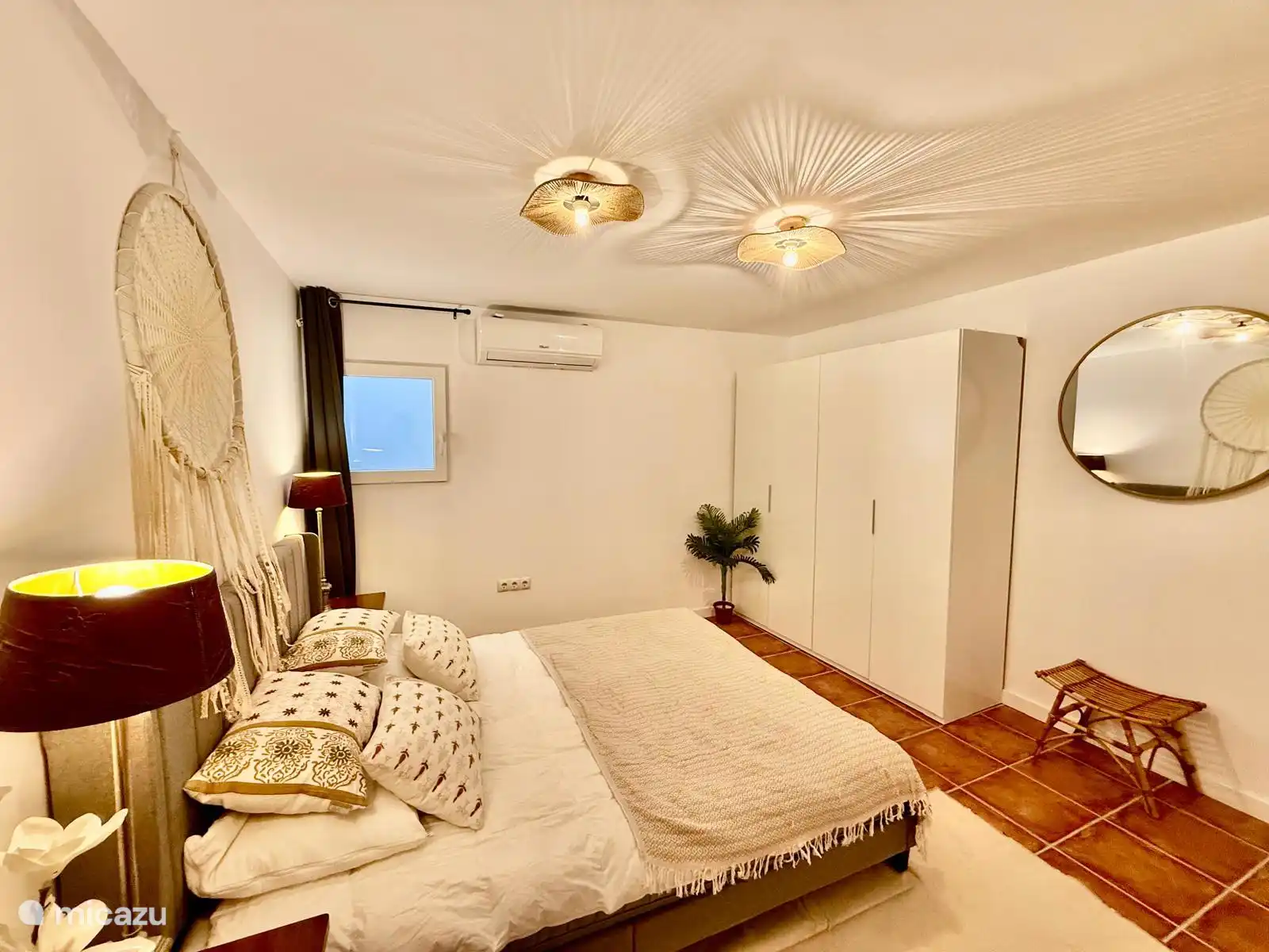 Chambre principale avec climatisation pour la climatisation et le chauffage, grande armoire et miroir.