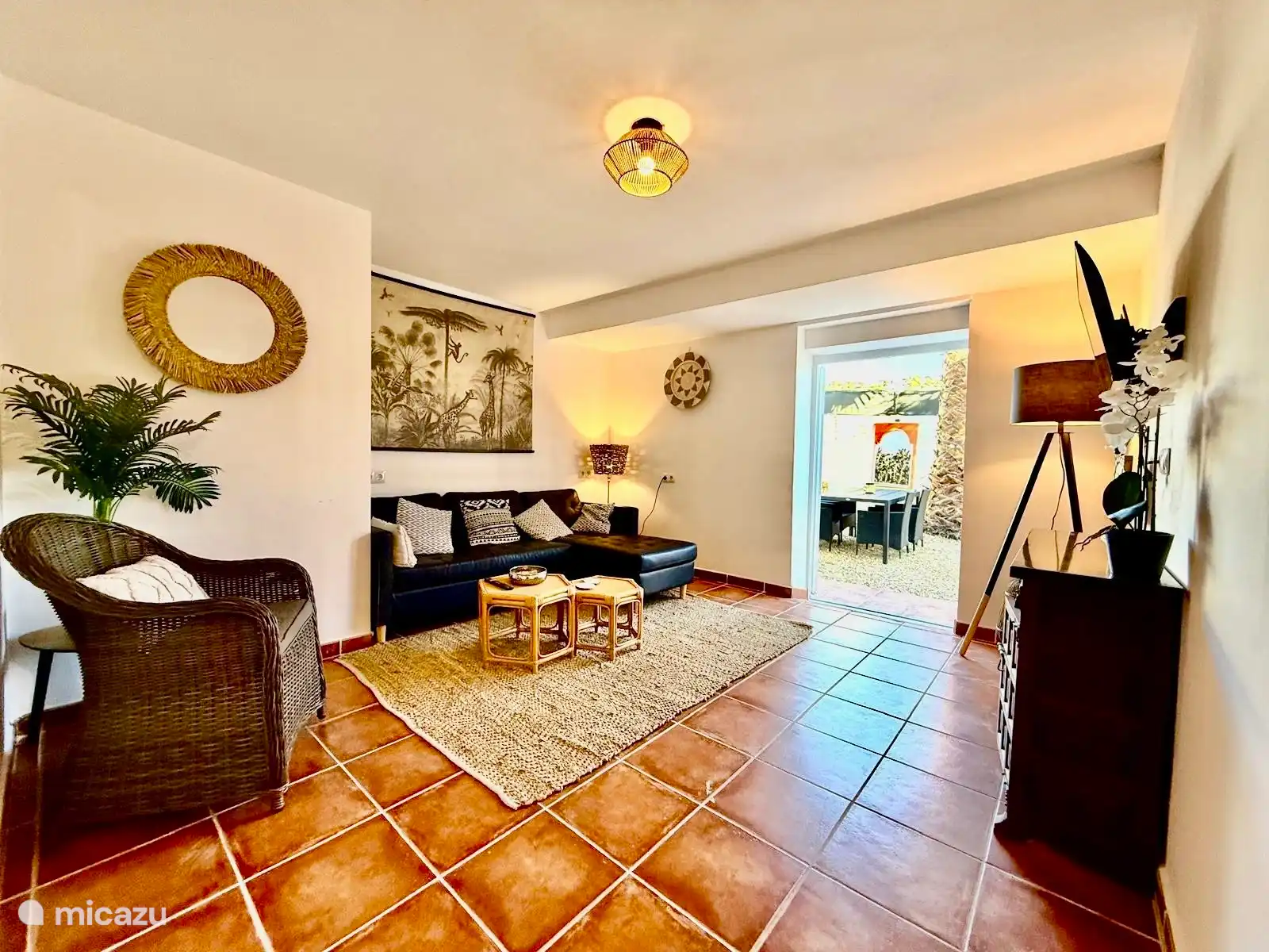 Salon avec porte-patio donnant sur le jardin et table à manger extérieure.