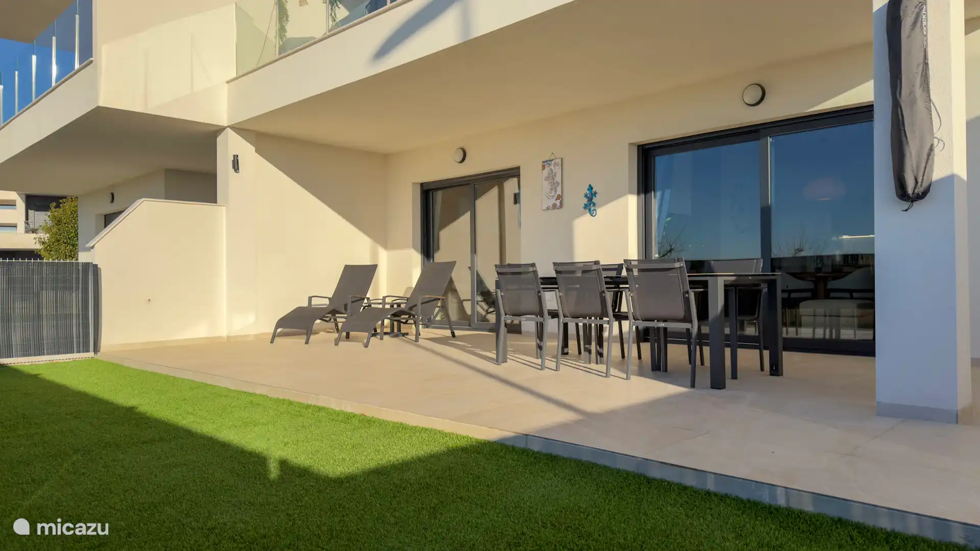 De ruime tuin op het zuiden, voorzien van 2 ligbedden en een tafel met met zes comfortabele stoelen.