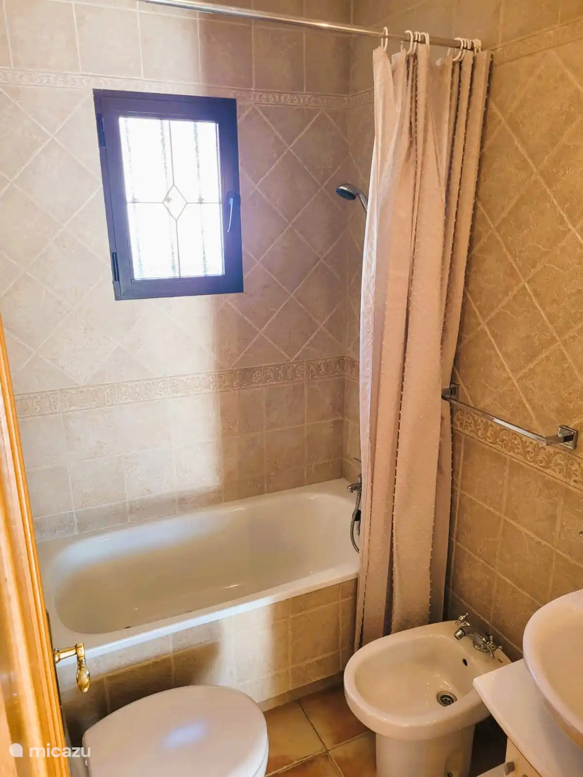 La deuxième salle de bain avec baignoire, toilettes, bidet et lavabo. 