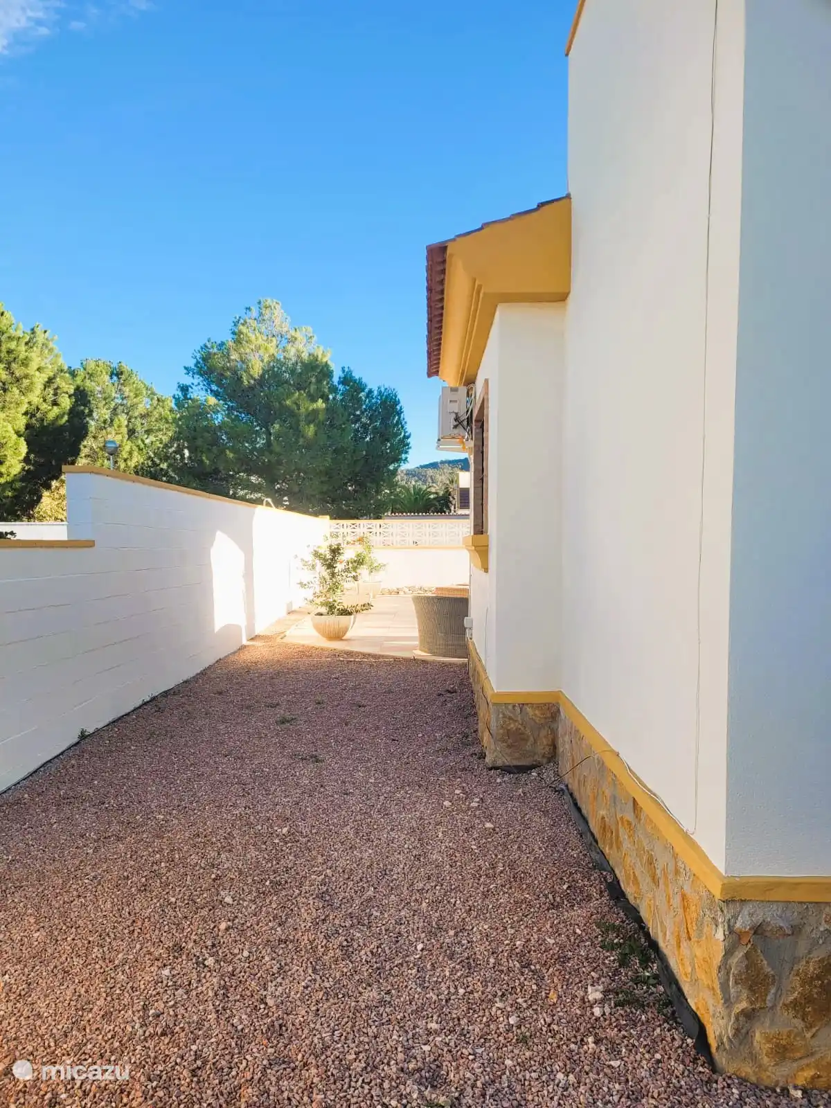 Derrière le côté de la maison, avec toujours un peu d’ombre. 