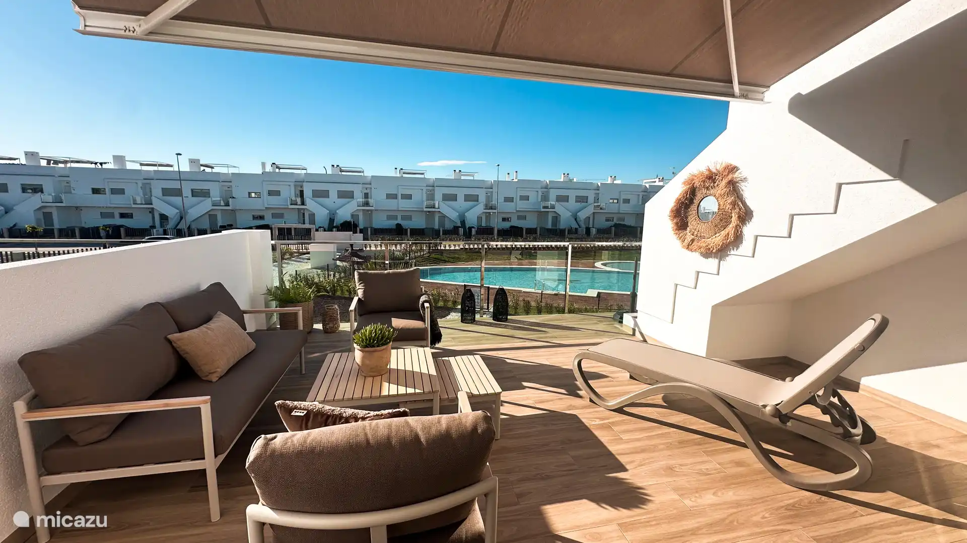 Het aan de woonkamer grenzende terras is gelegen op het zuidwesten en heeft uitzicht op het zwembad (1e verdieping).