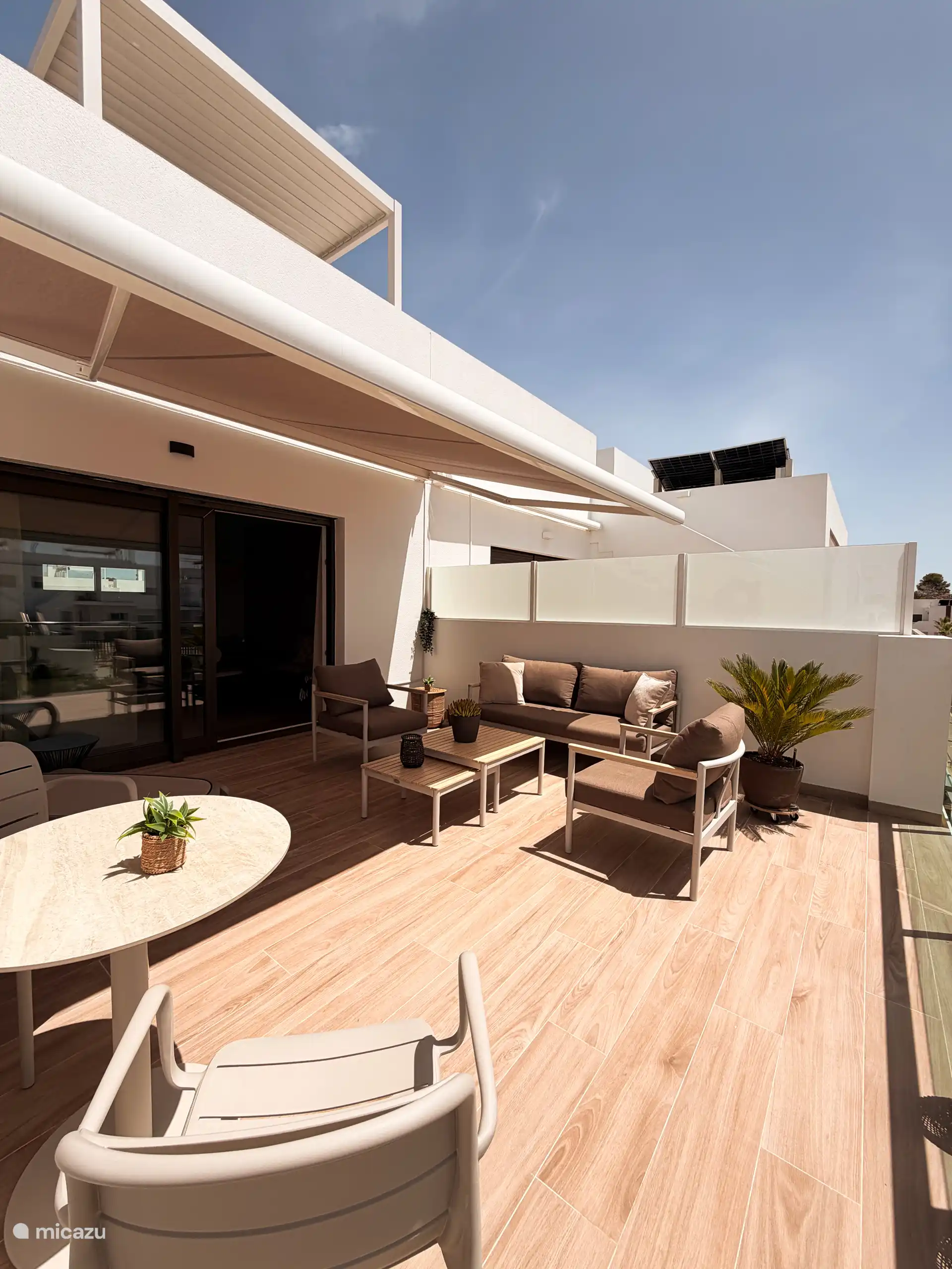 Sonnige Terrasse mit Markise und Sichtschutz