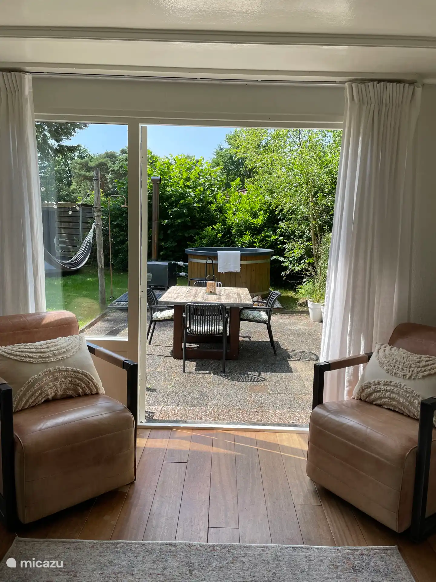 Wohnzimmer mit Terrassentüren zum geräumigen, umzäunten Garten