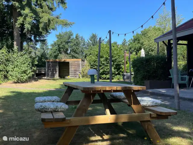 Boshuisje Elva huren in Nederland, Gelderland, Ermelo - blokhut / lodge In de omgeheinde tuin kun je fijn loungen op de stoelen. Ook is er een picknicktafel. Onder de bomen staat de houtgestookte hottub met sfeervolle verlichting.